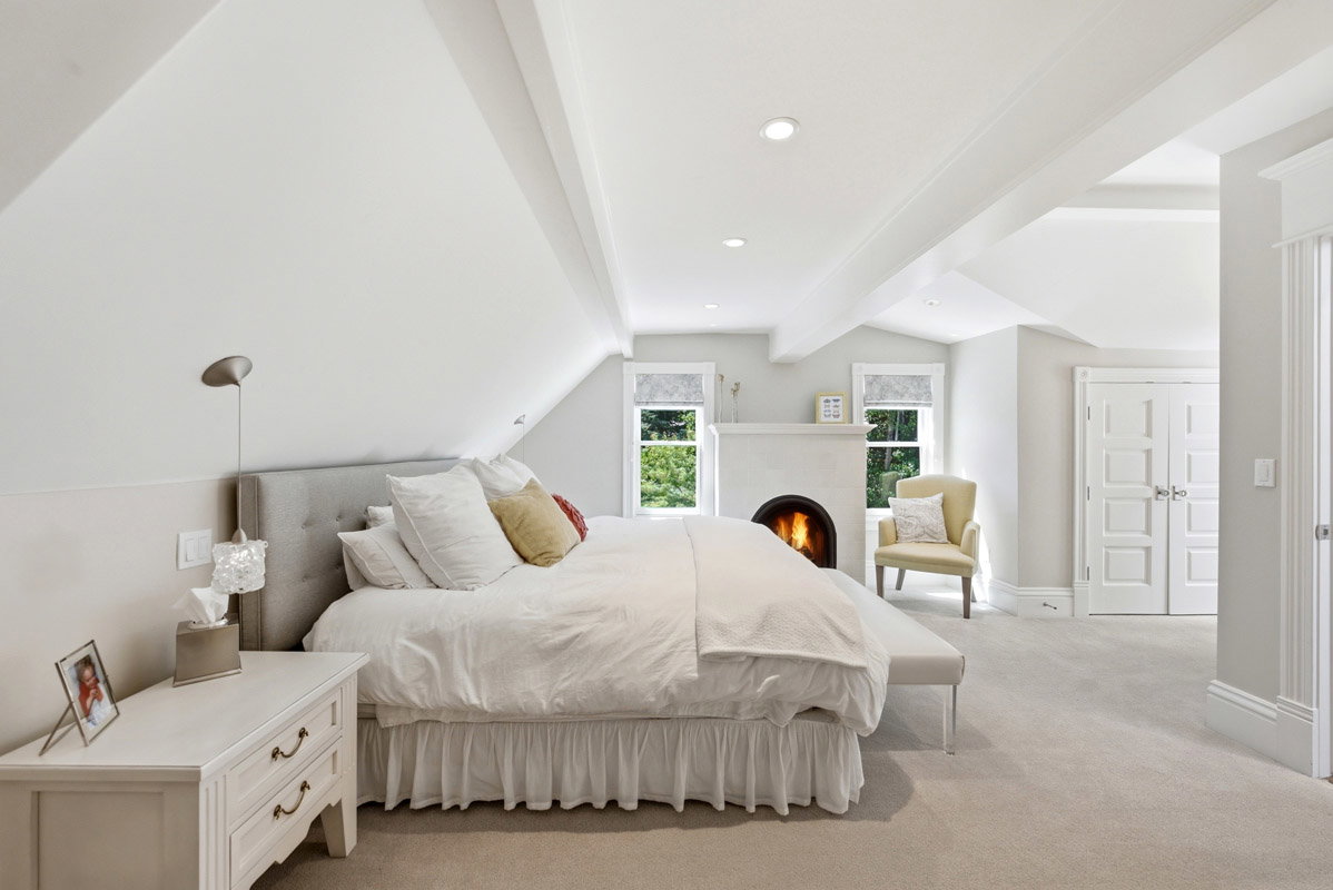 Vaulted ceiling with exposed beams, recessed lighting, and a built-in fireplace