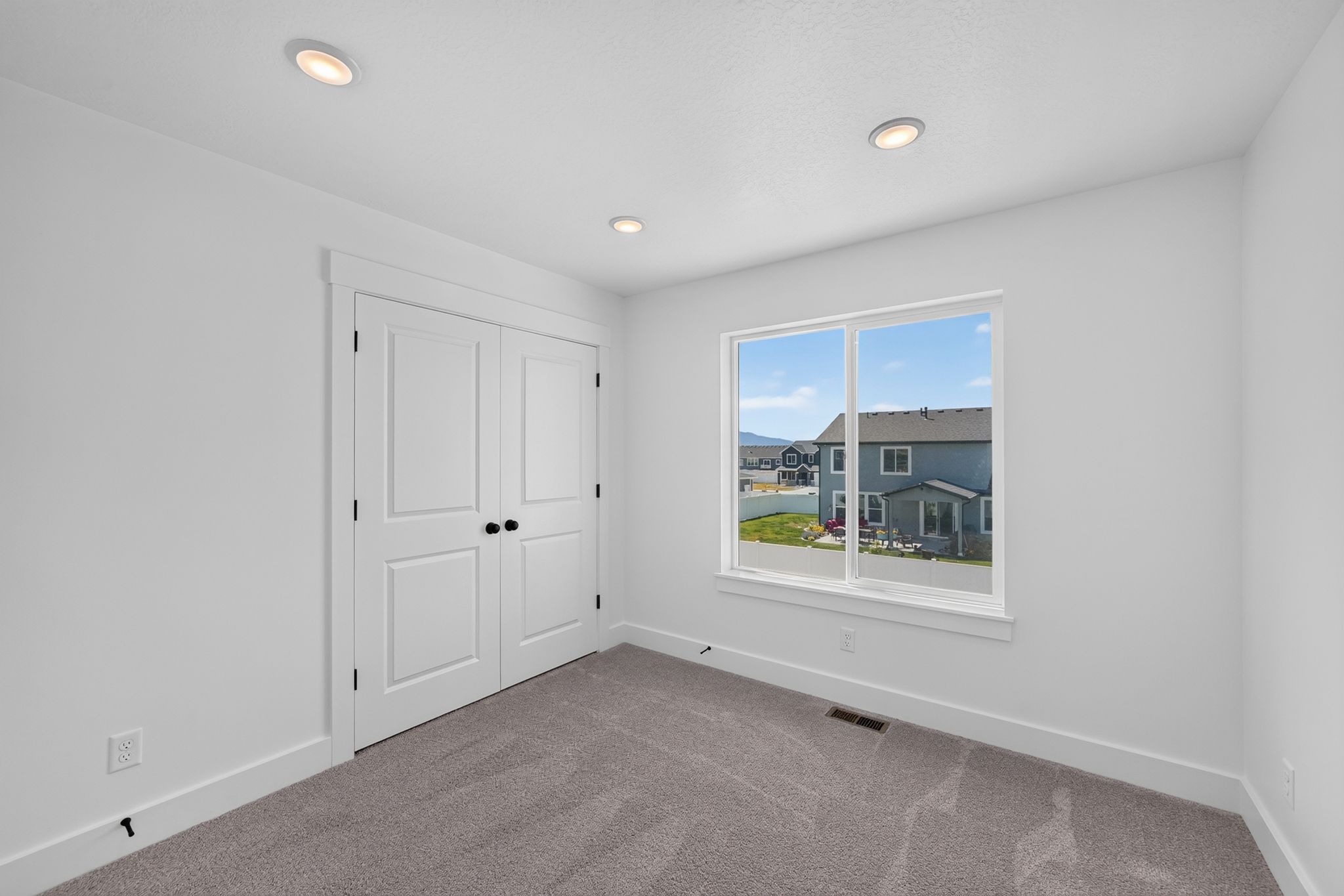 Bedroom 3 Neutral white walls with recessed ceiling lighting