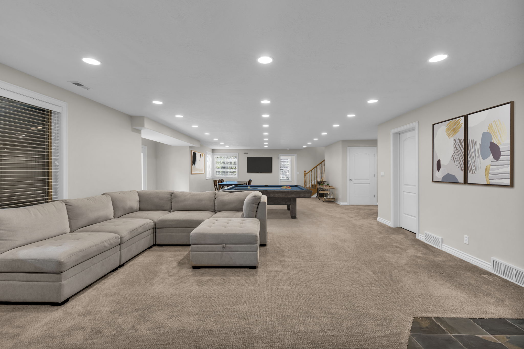 Spacious recreation area featuring recessed lighting, light gray wall paint, and plush carpet flooring