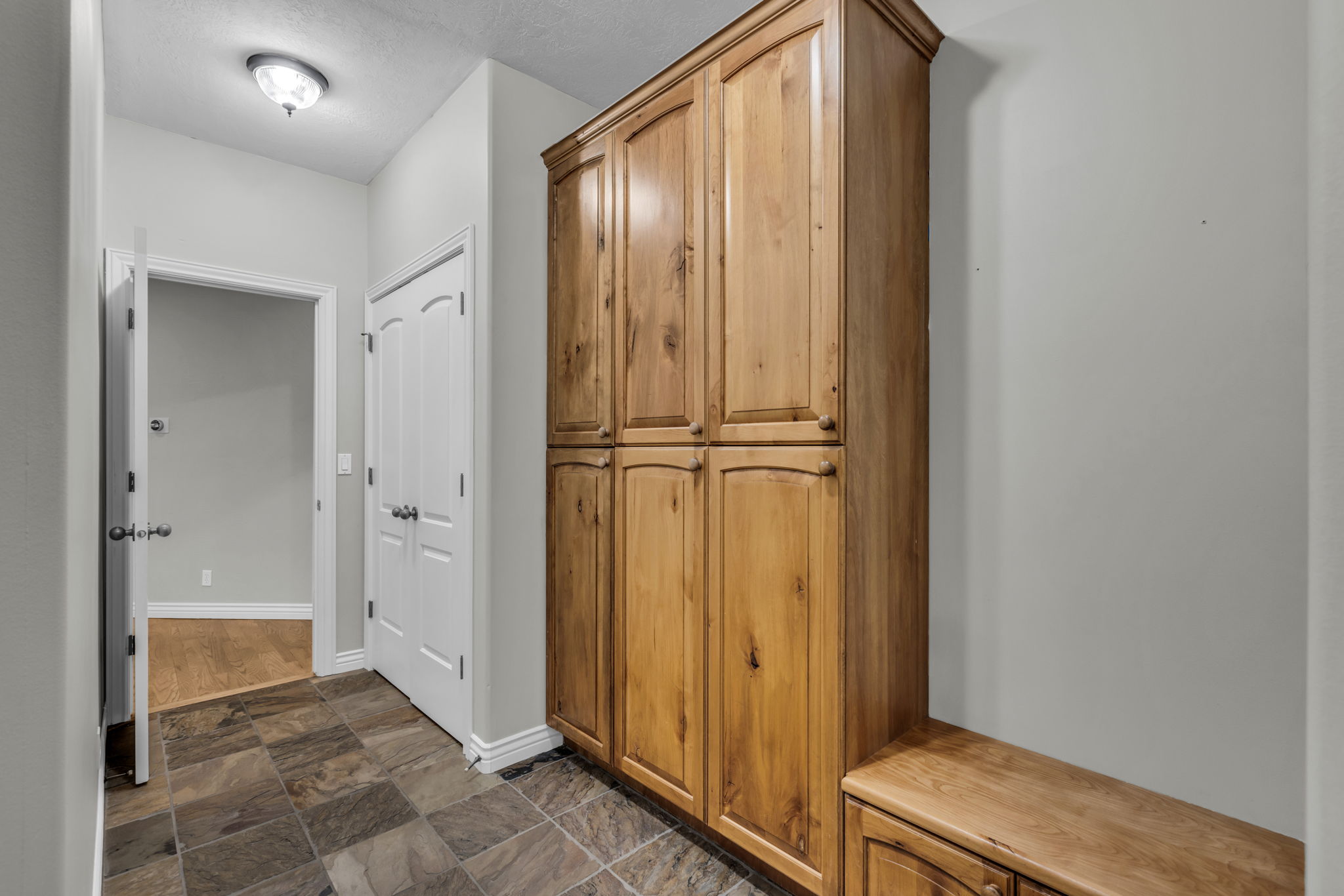 Full-height wood cabinetry with upper and lower storage, complemented by a wood-finish base cabinet