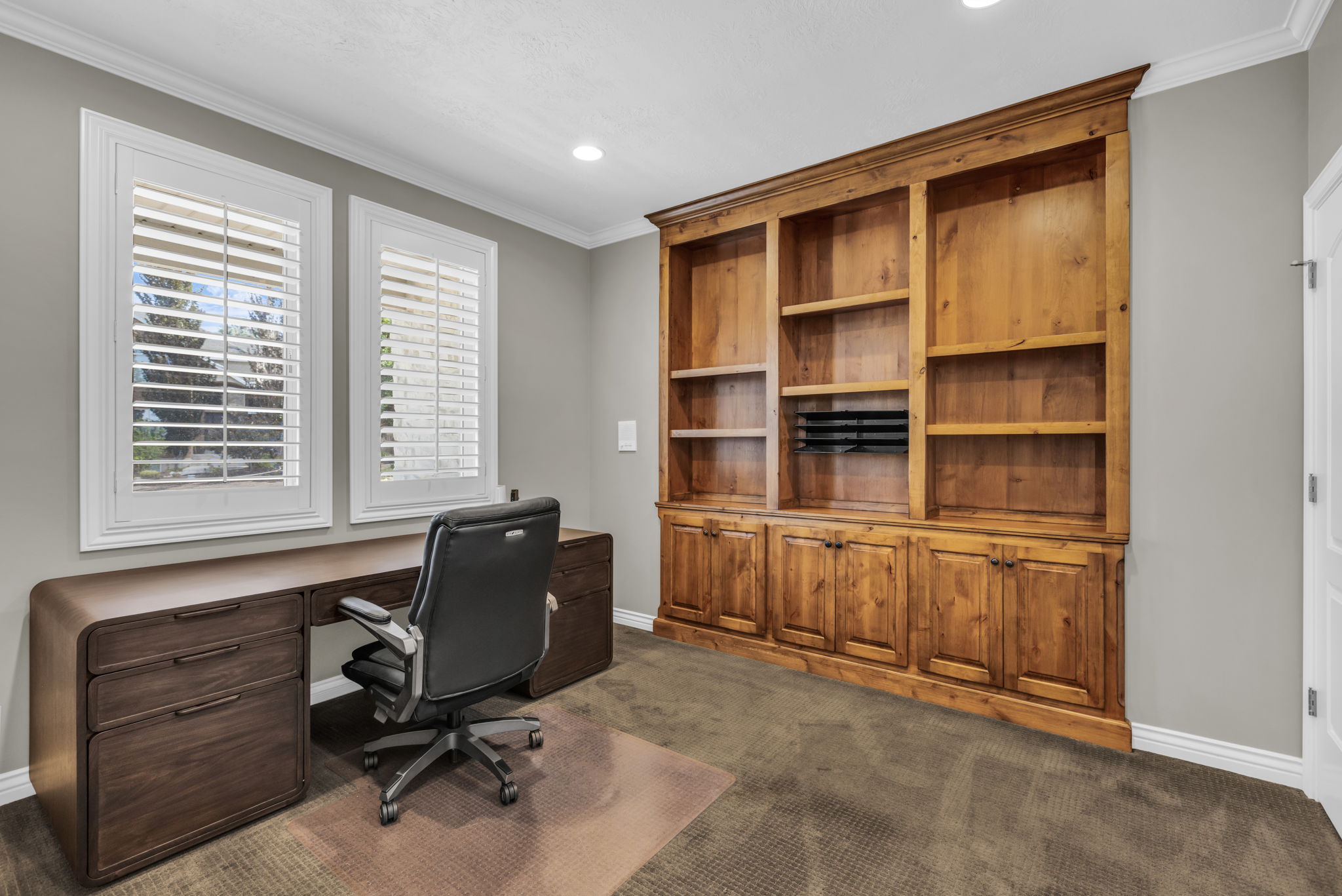 Room featuring a built-in wood-finish shelving unit with integrated lower cabinetry