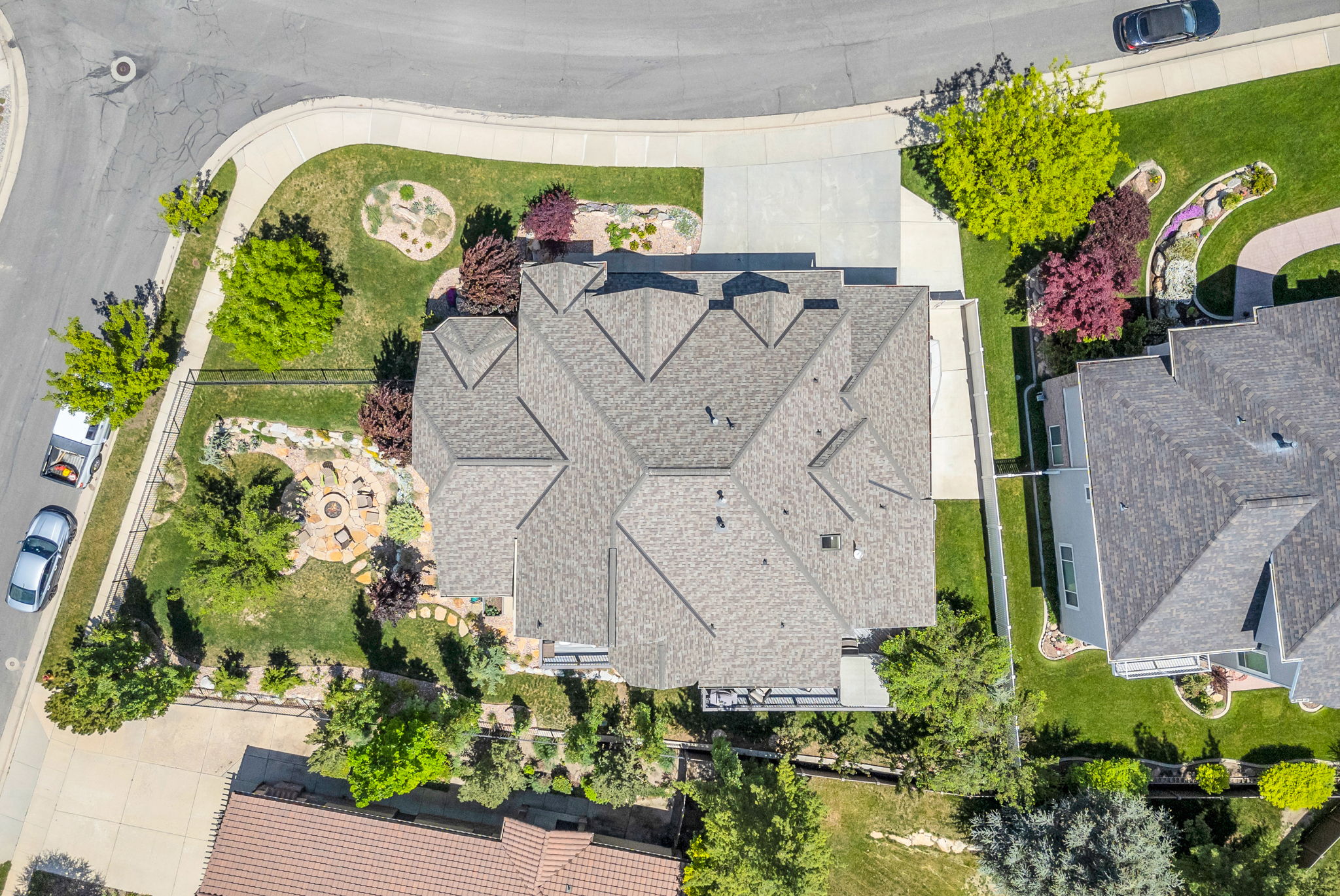 Expansive property featuring a multi-gabled roofline, lush green lawns, and a concrete driveway