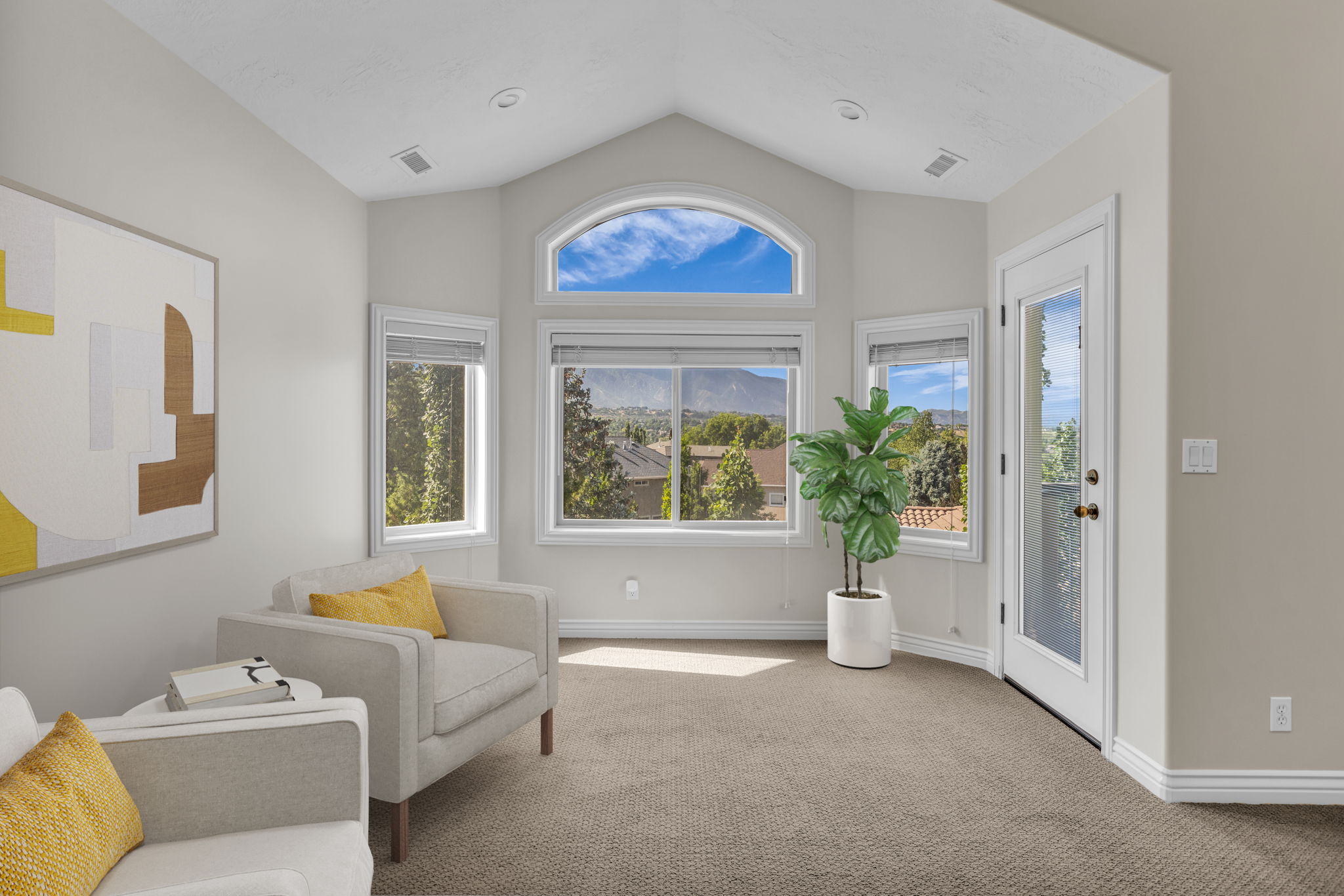 Bright room featuring a vaulted ceiling with recessed lighting, an arched transom window, and multiple picture windows