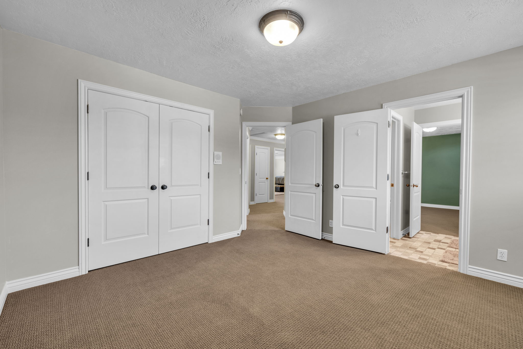 Interior room featuring neutral wall paint, brown carpet flooring, and white baseboards