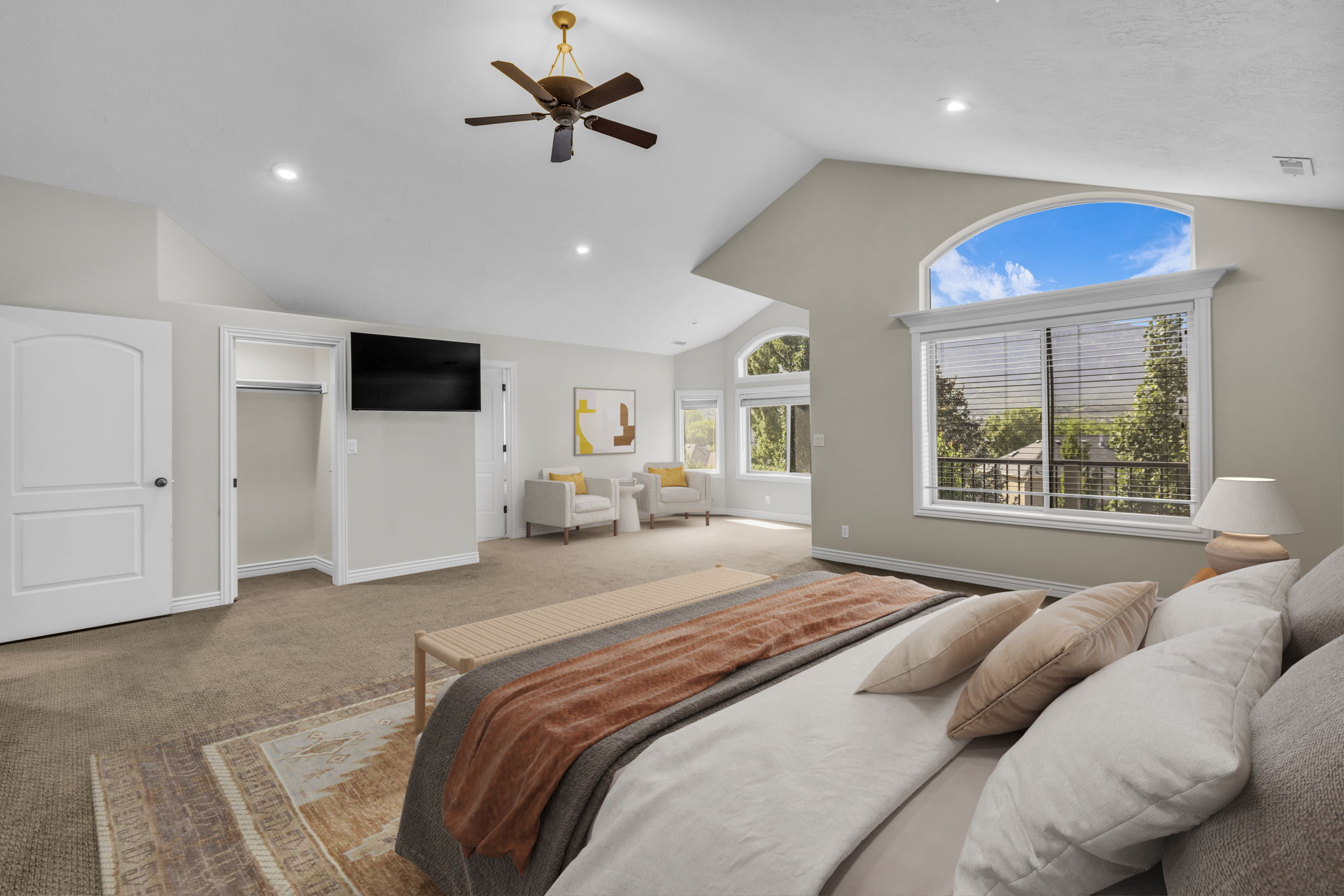 Vaulted ceiling room featuring a large arched window, multiple recessed lights, a ceiling fan, and carpet flooring