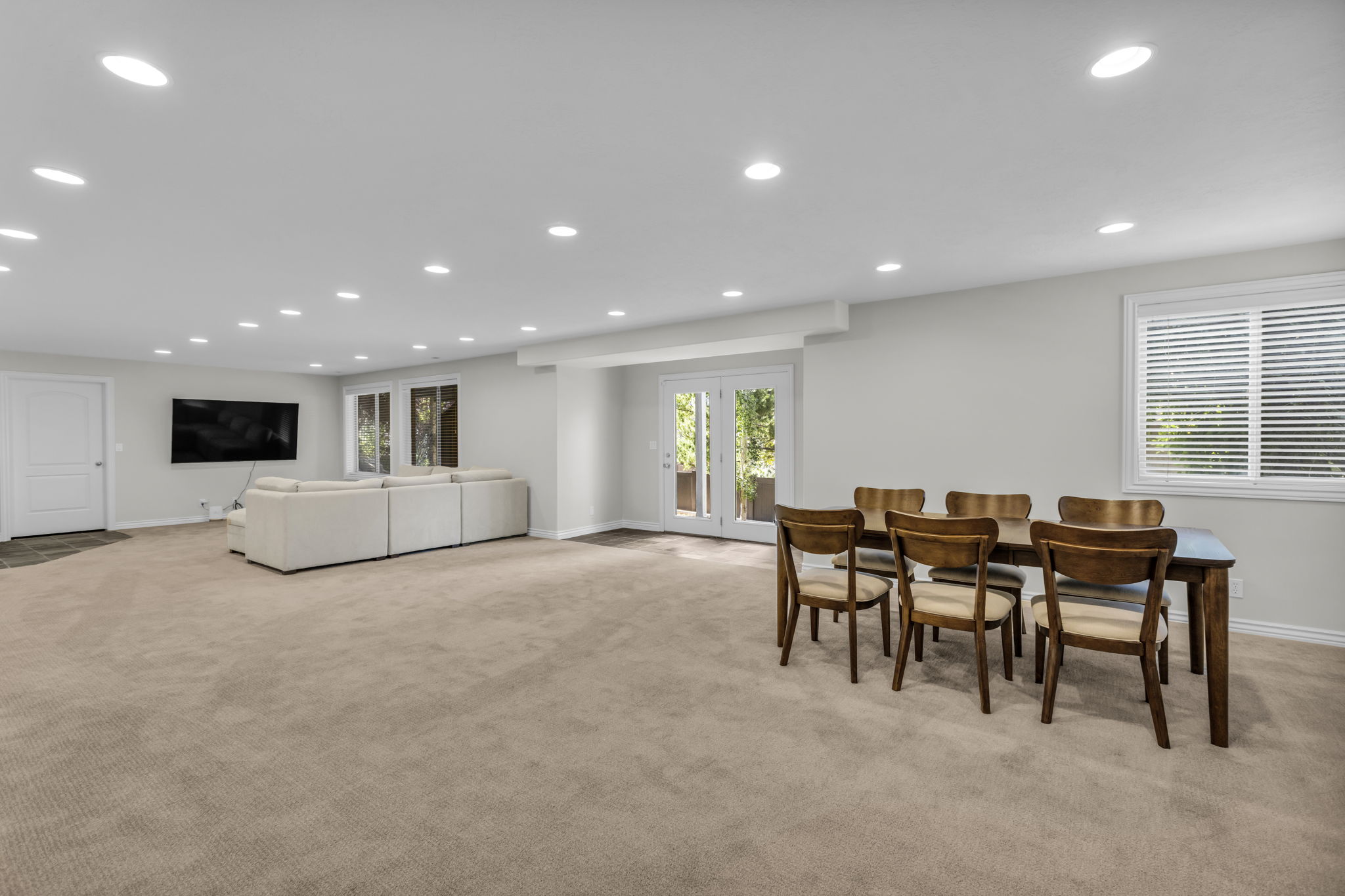 Spacious lower-level area featuring recessed lighting, light carpeting, and white walls