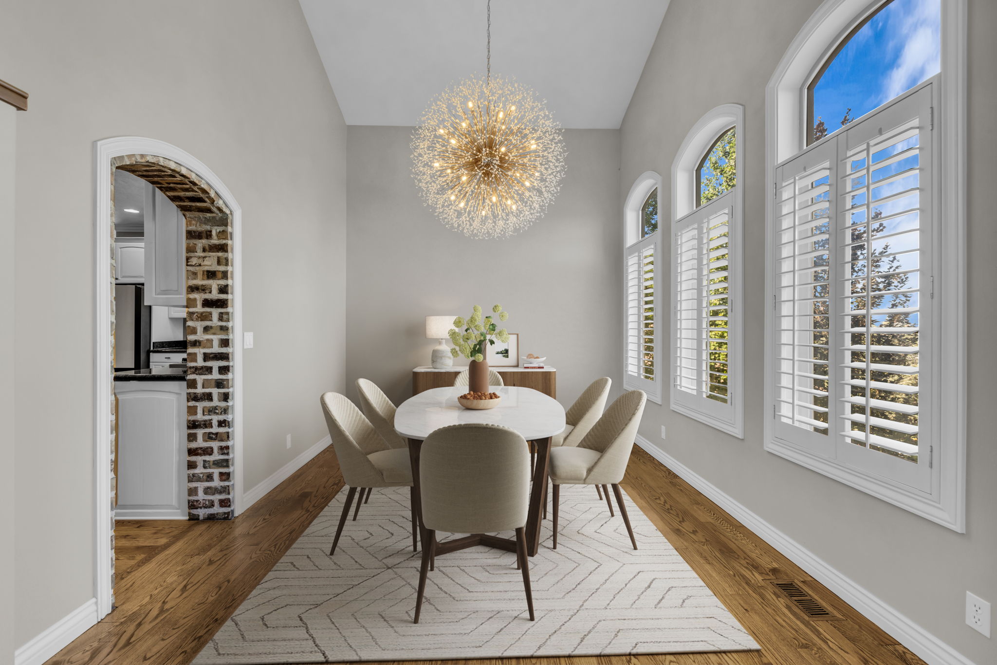 Dining area featuring vaulted ceilings, wood-finish flooring, and a decorative chandelier