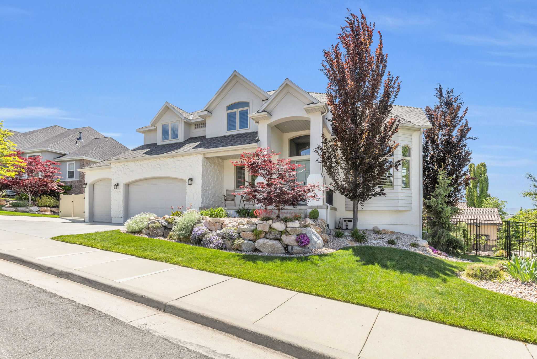 Traditional-style residence featuring a textured stucco exterior and a multi-gabled roofline