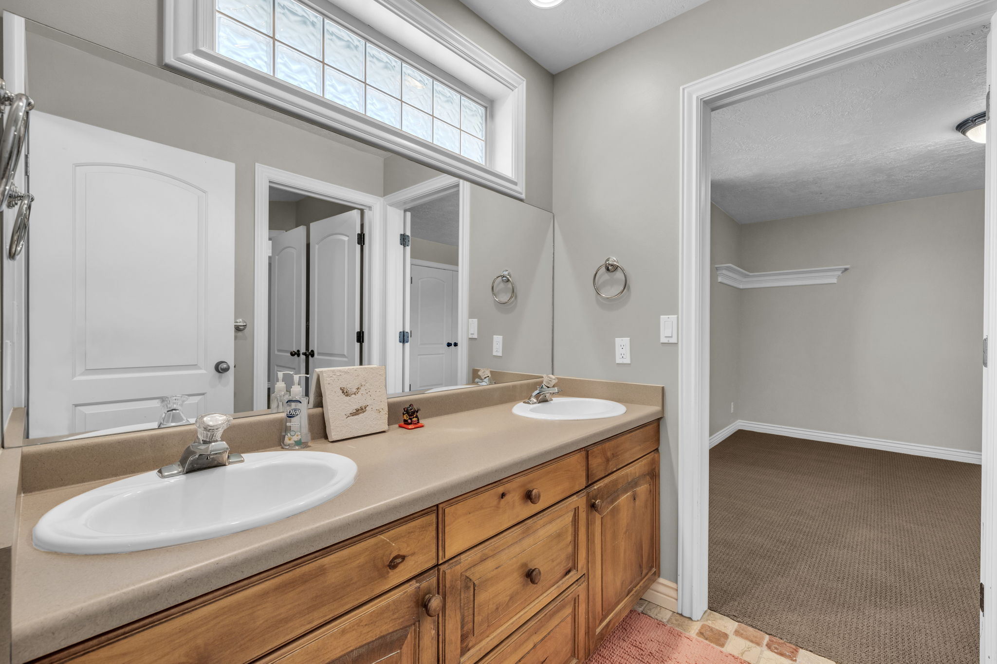 Double vanity featuring wood cabinetry, integrated sinks, and a laminate countertop