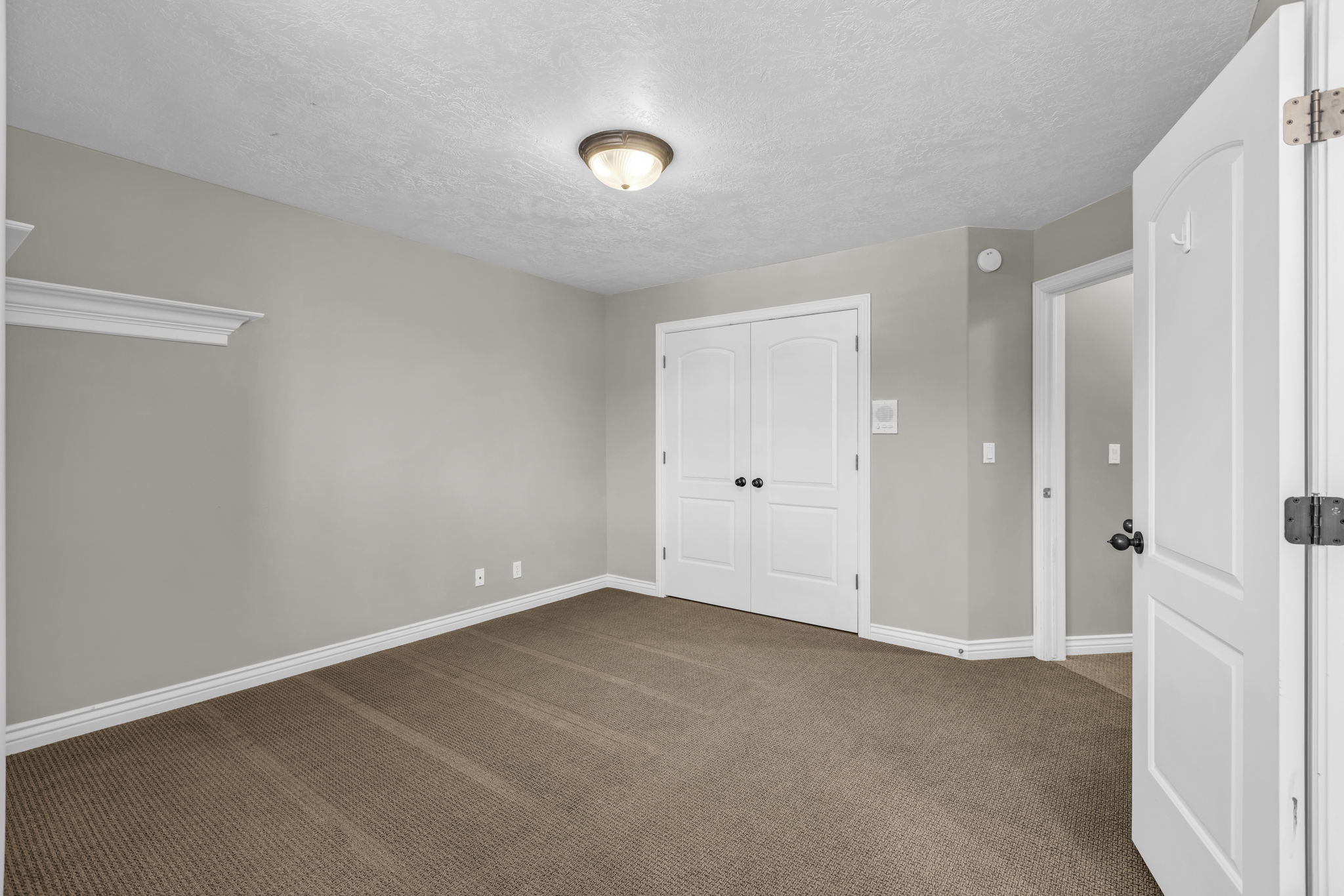 Carpeted room with light gray walls, white baseboards, and a white ceiling