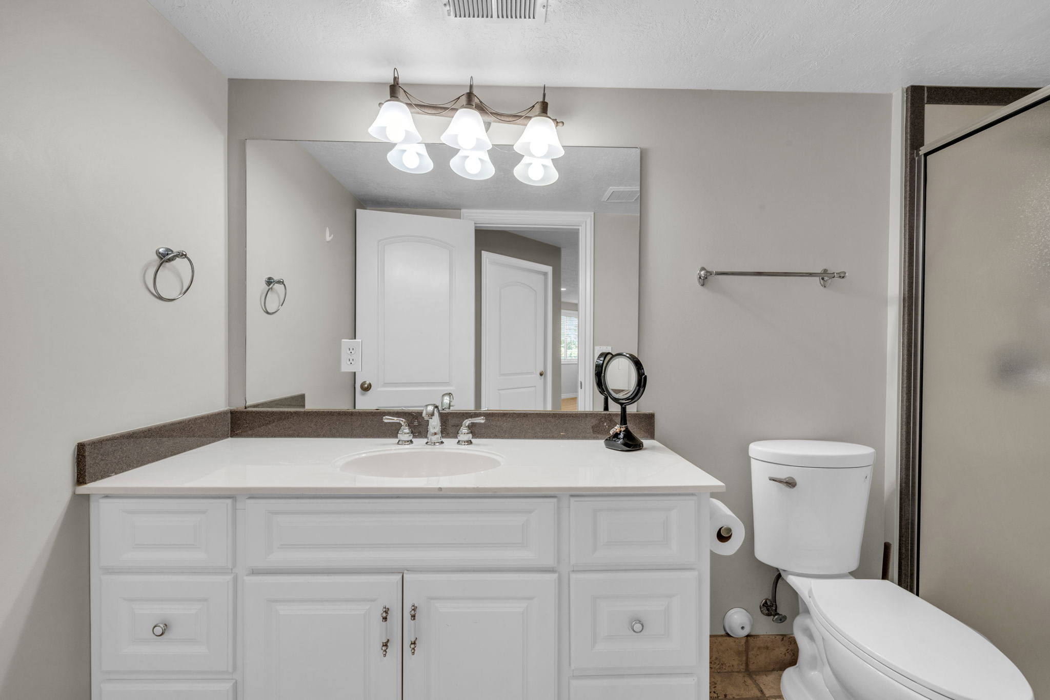 Bathroom vanity with white cabinetry, a white countertop, and a built-in sink