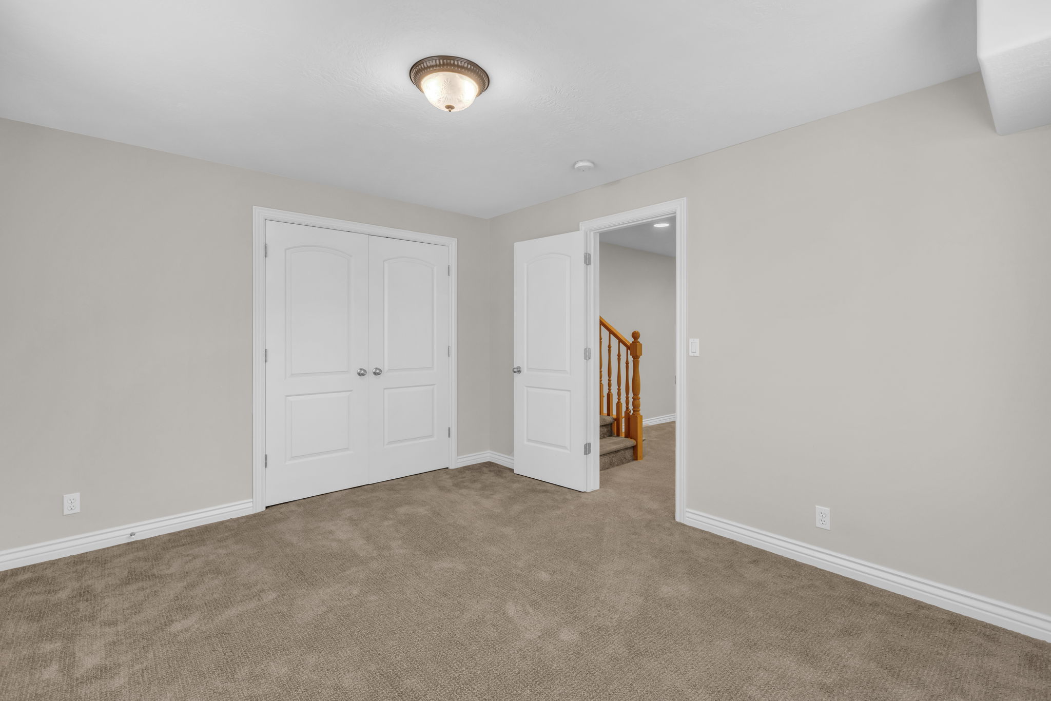 Neutral-toned wall paint throughout, complemented by a textured carpet flooring