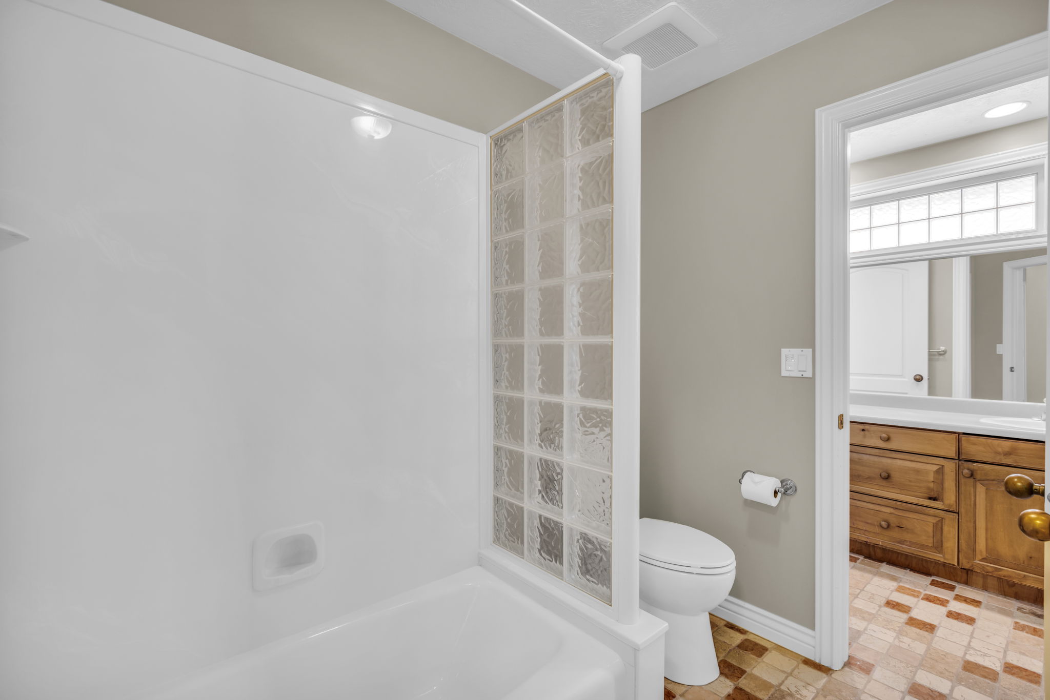 Tub and shower combination featuring a glass block privacy wall