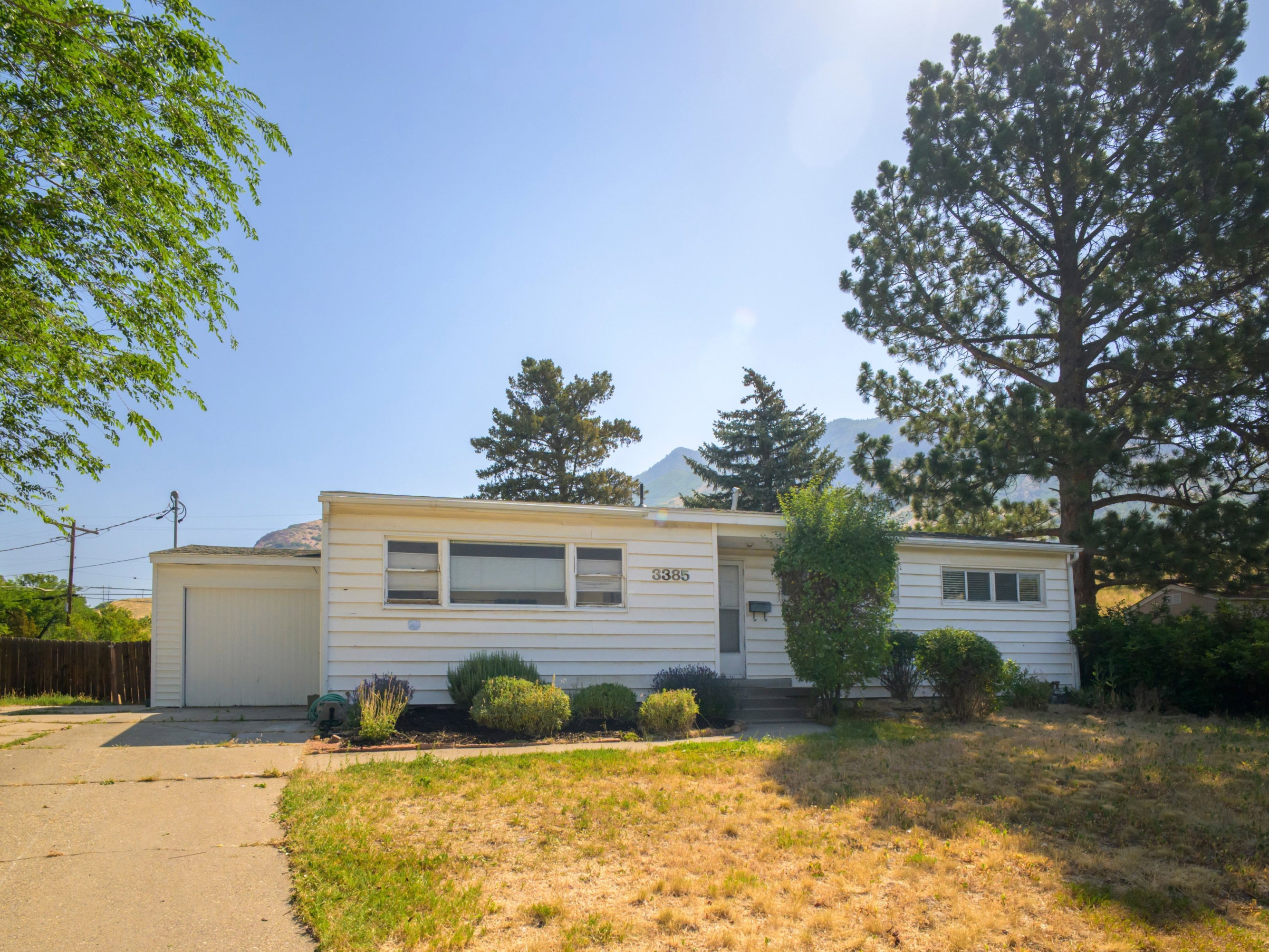 Single-story residence featuring white siding and a front-facing garage