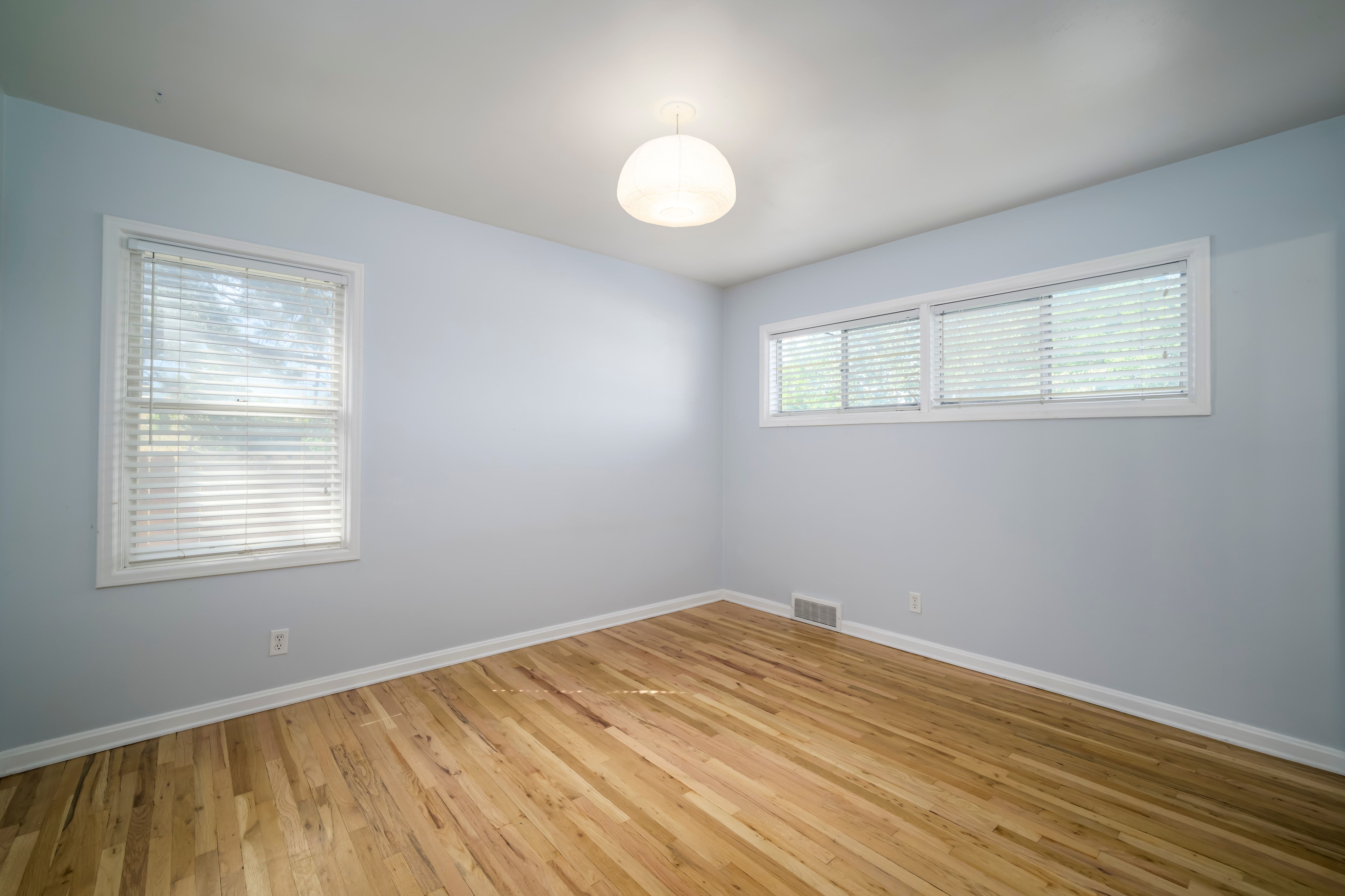 Hardwood flooring complements light blue wall paint and white trim