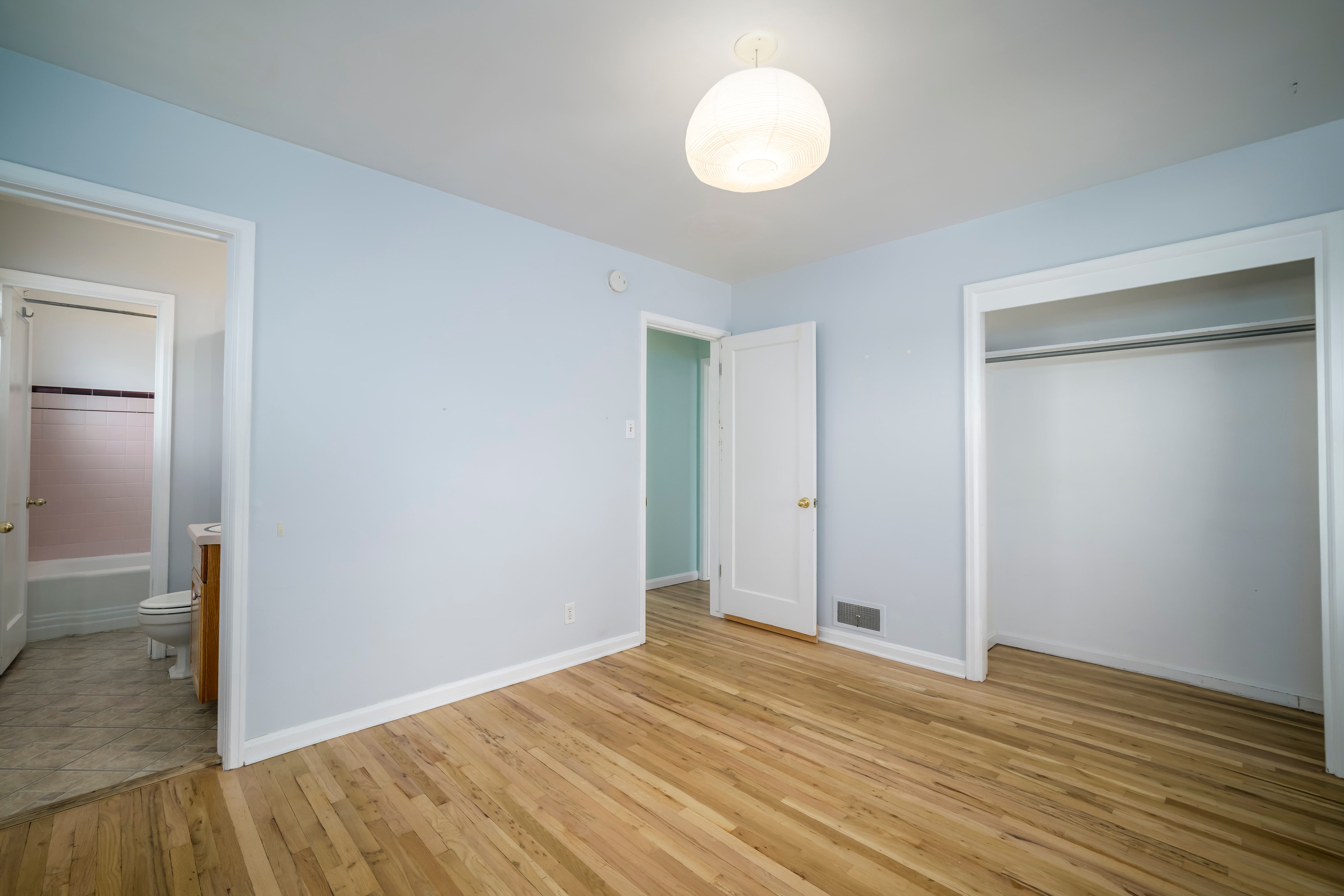 Light blue wall paint complementing wood-finish flooring