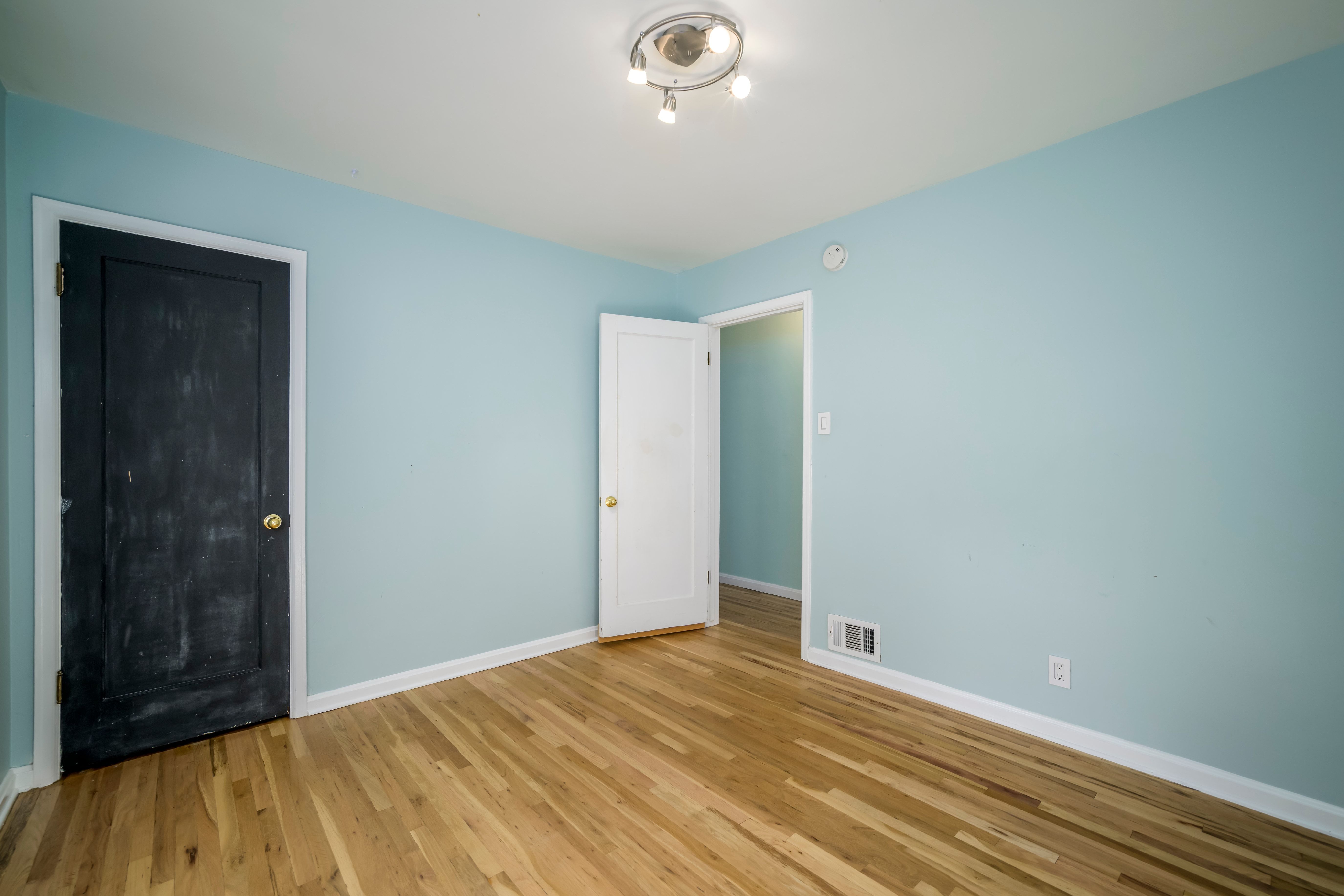 Light wood-finish flooring with white baseboards
