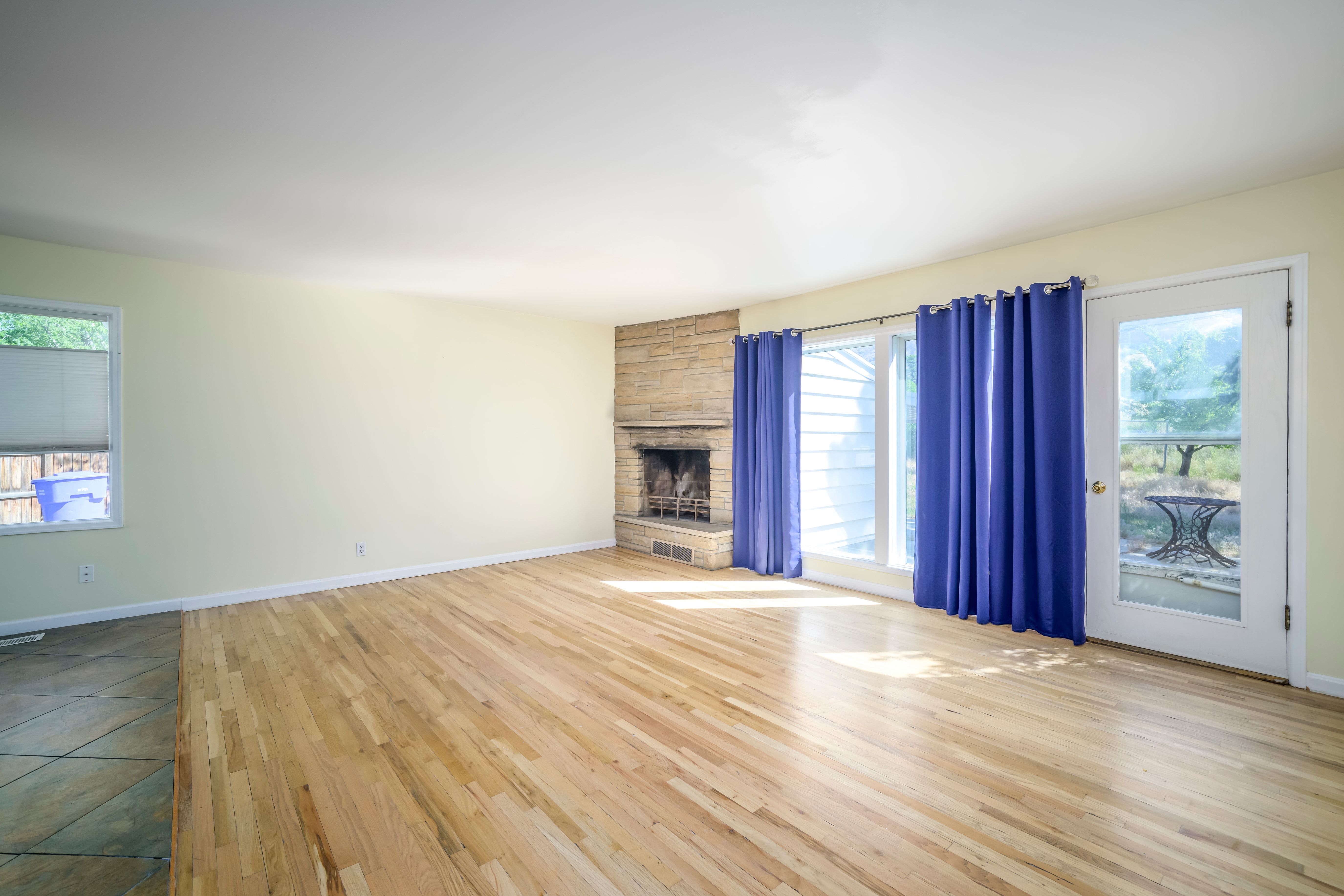 Hardwood flooring complements a stone-clad fireplace