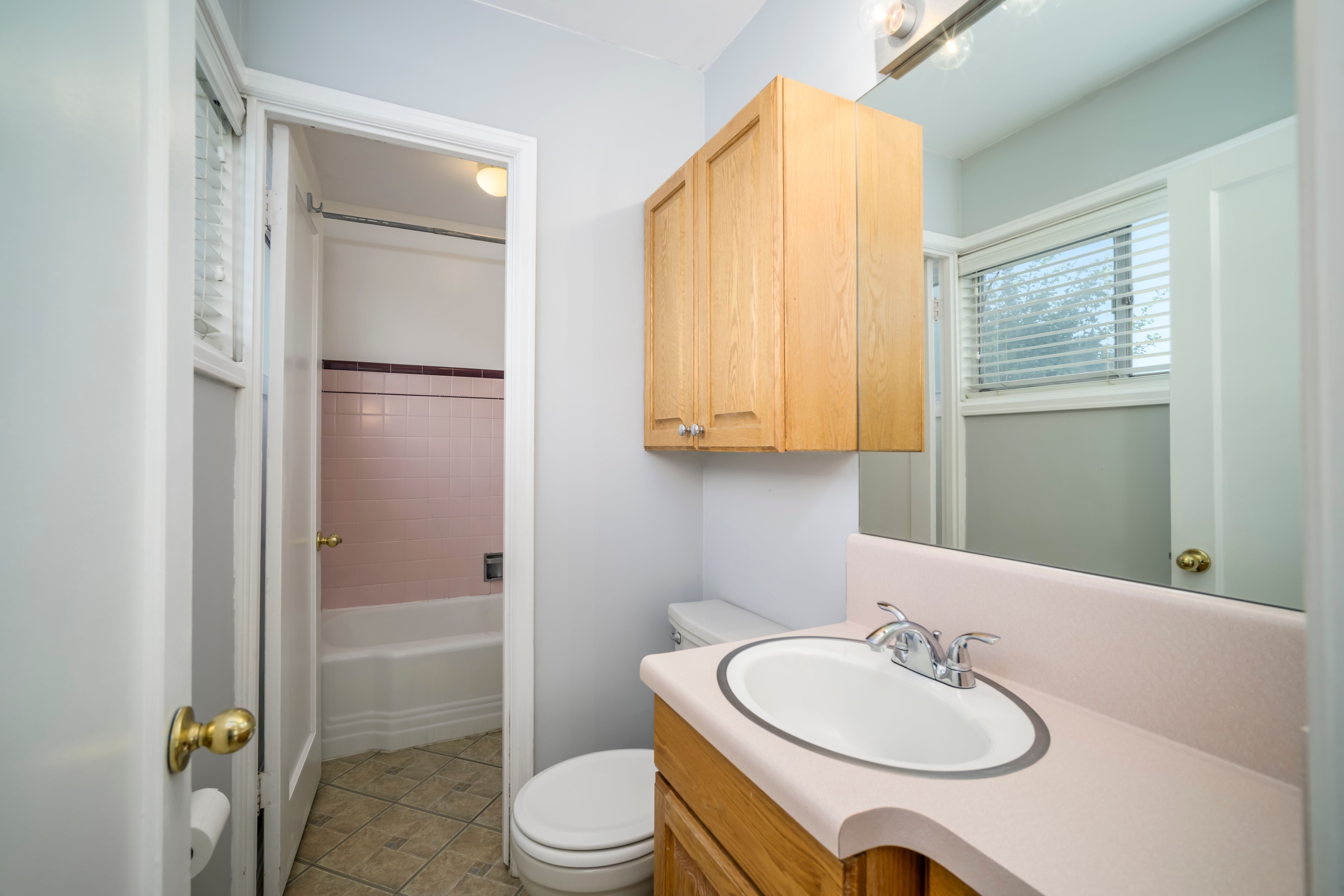 Bathroom vanity with an integrated sink, polished chrome faucet, and wood-finish cabinetry