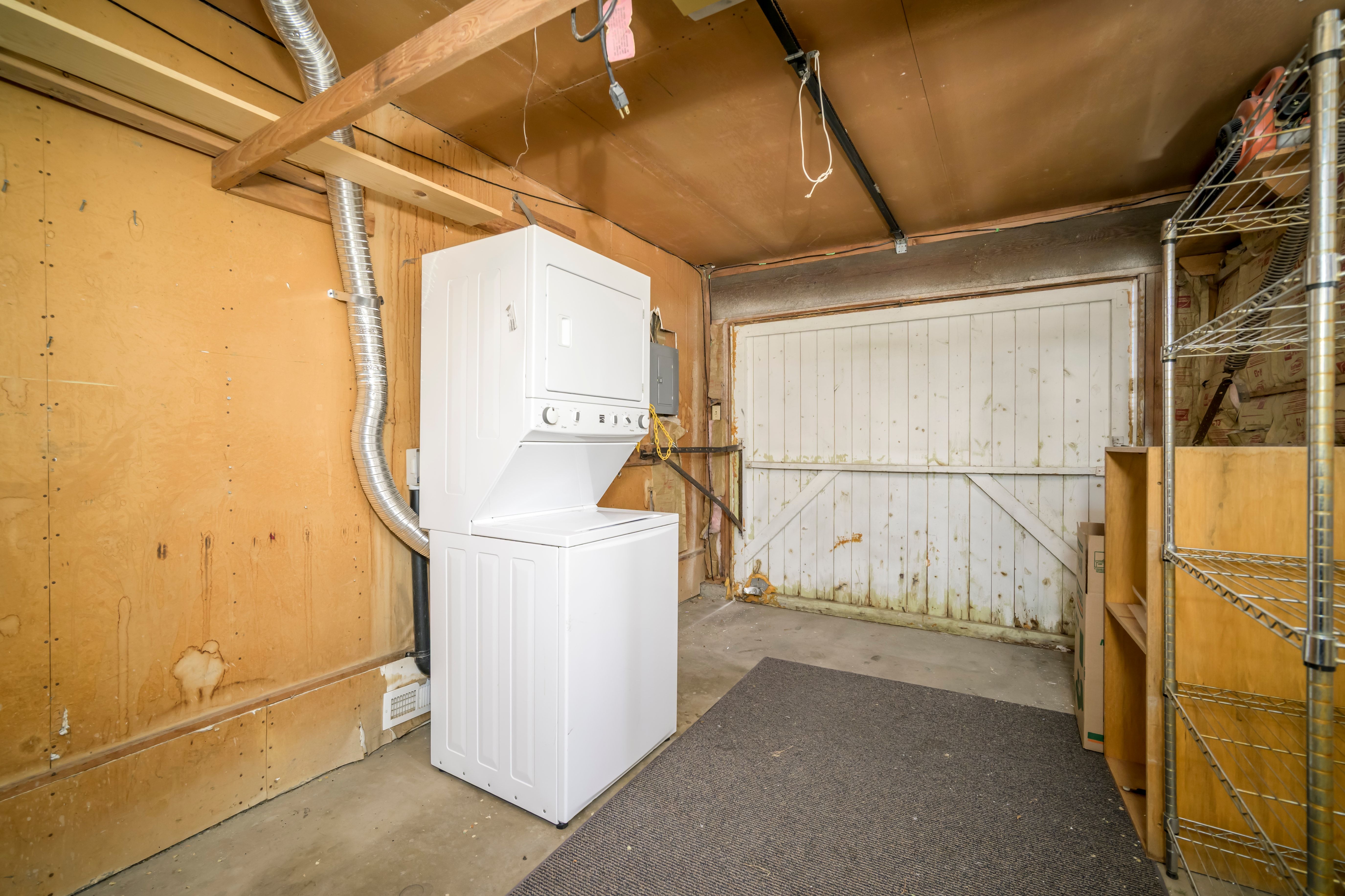 Dedicated laundry area featuring a stacked washer and dryer unit