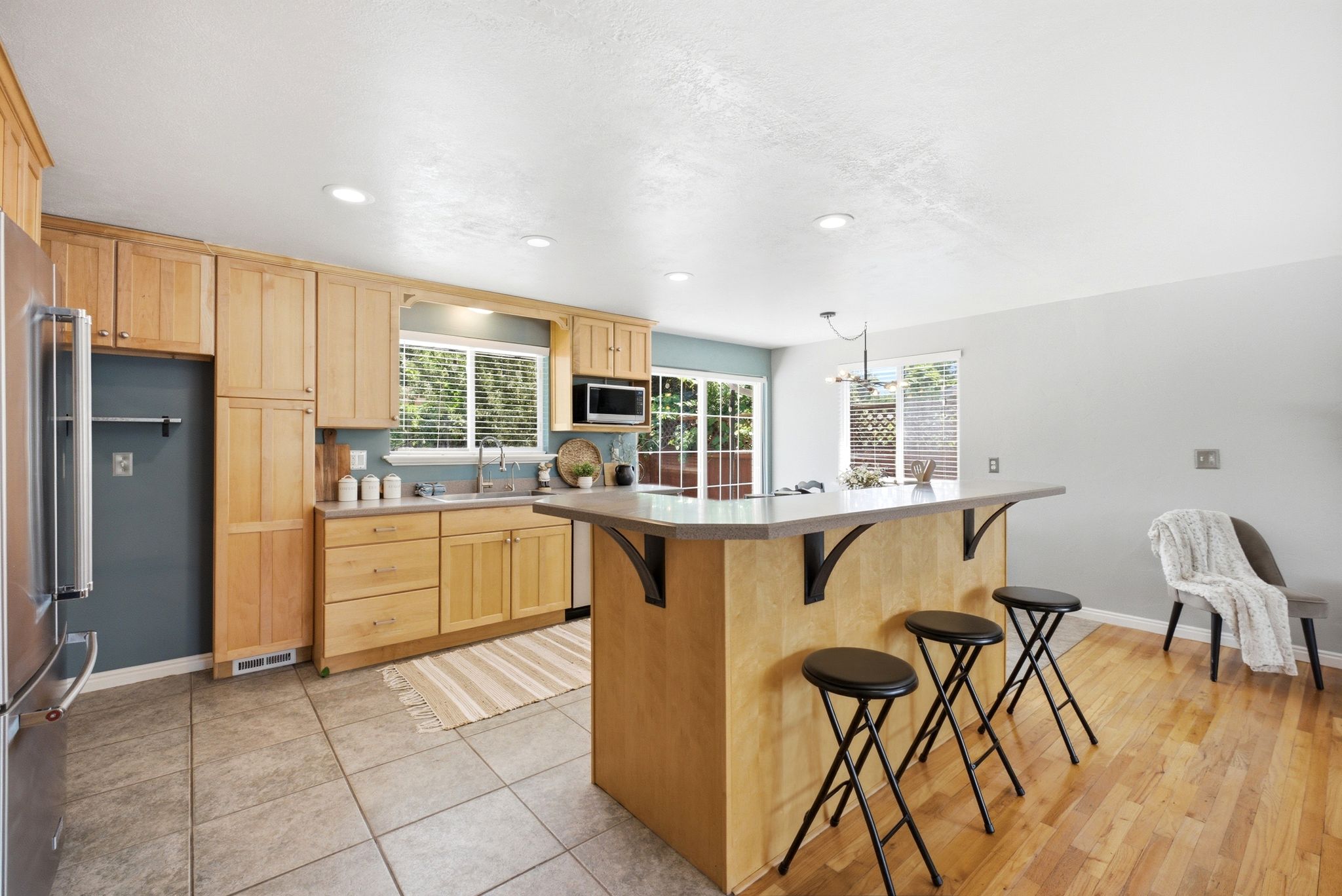 Kitchen featuring light wood cabinetry and a stainless steel refrigerator