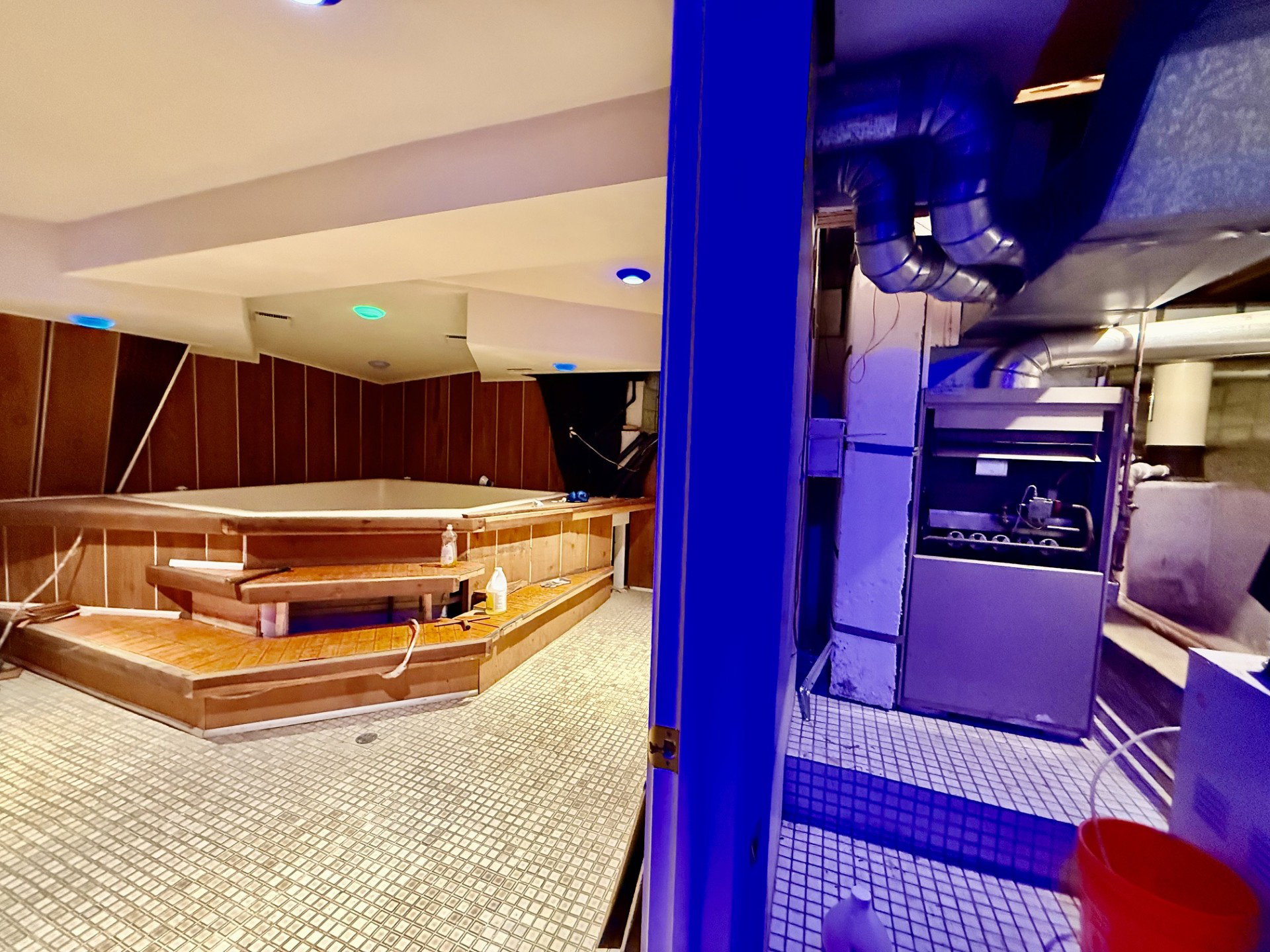 Indoor spa area featuring a built-in hot tub with wood paneling and integrated steps