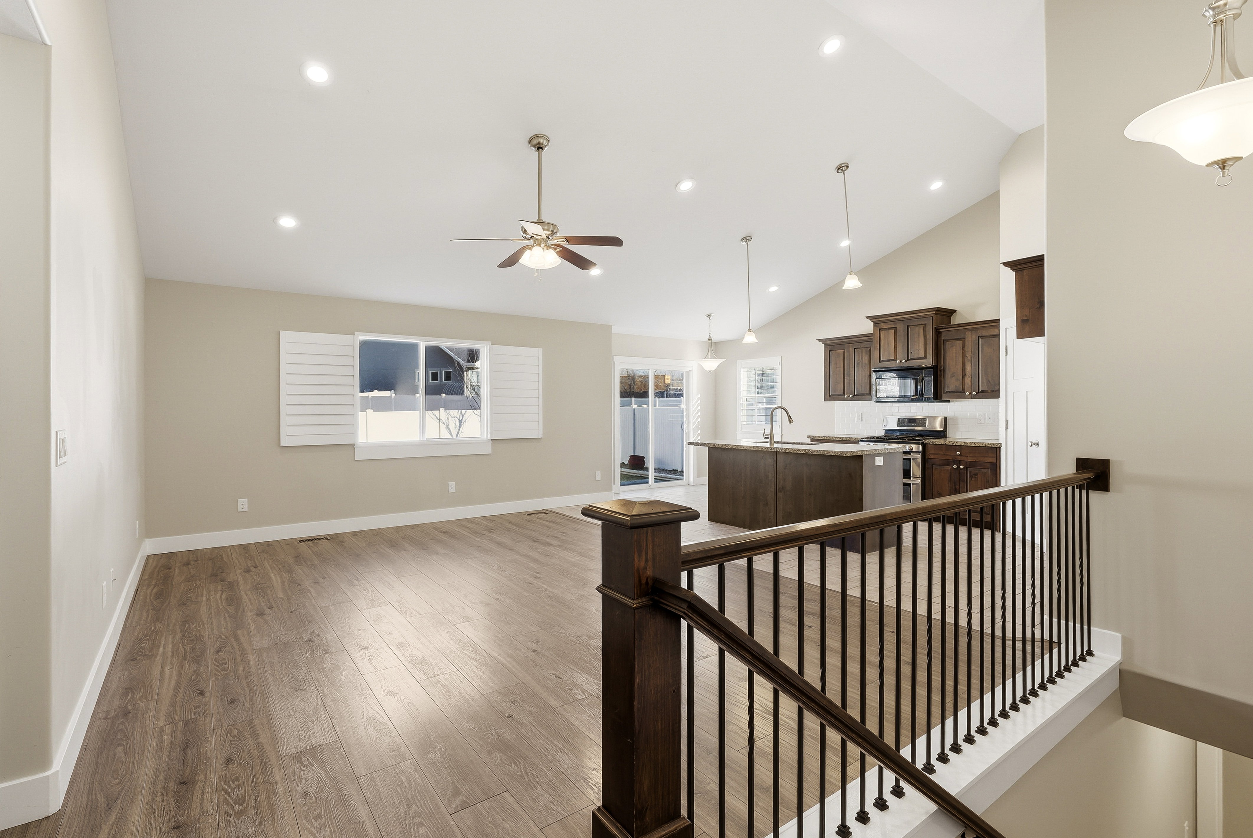 Vaulted ceilings enhance the open-concept living space, featuring LVP flooring, natural light and recessed lighting