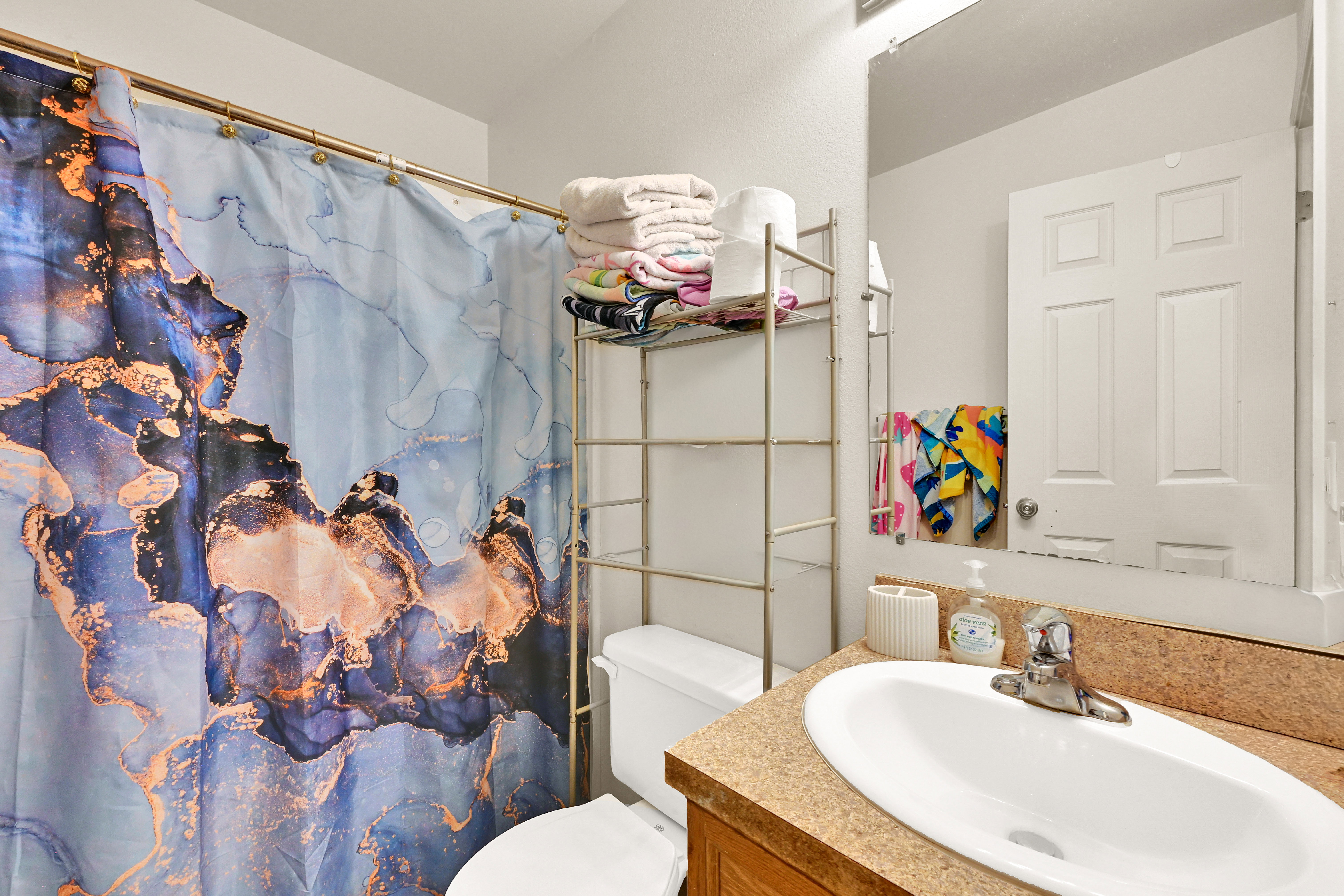 Bathroom featuring a built-in vanity with a countertop and integrated sink, a wall-mounted mirror, and a toilet