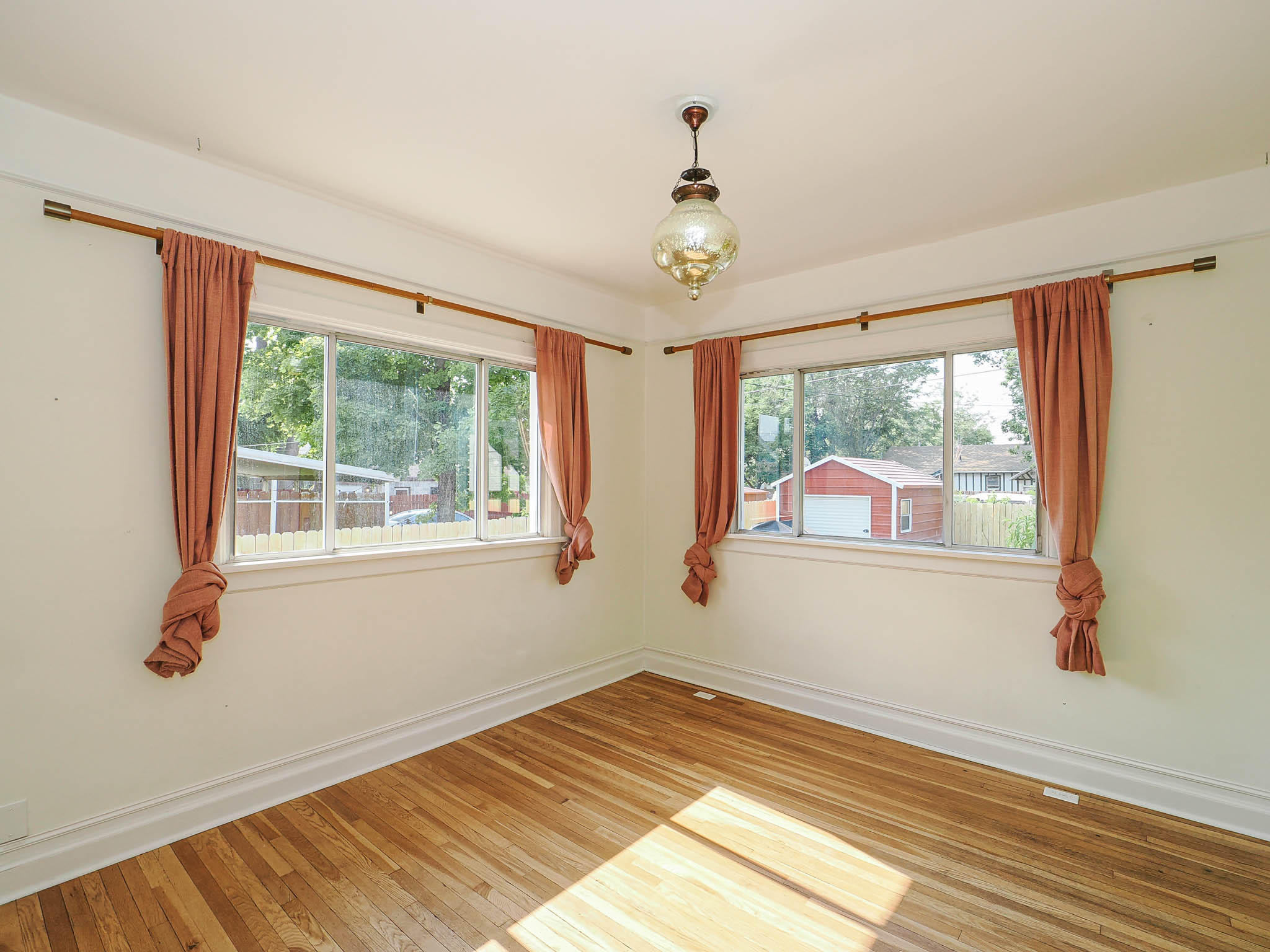 Hardwood flooring and two large windows with natural light