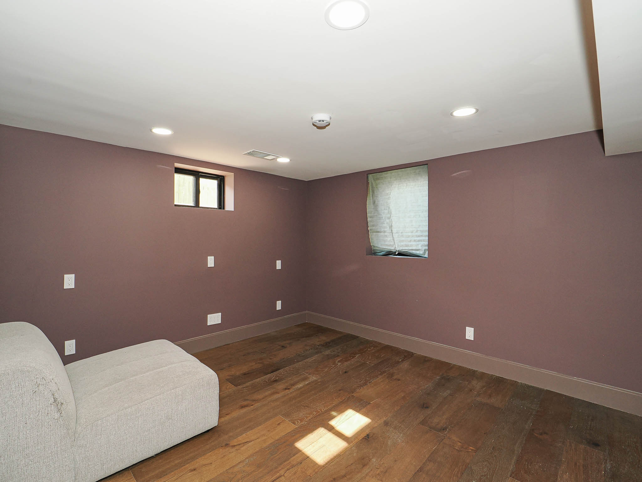Room featuring wood-finish flooring, recessed ceiling lighting, and two windows