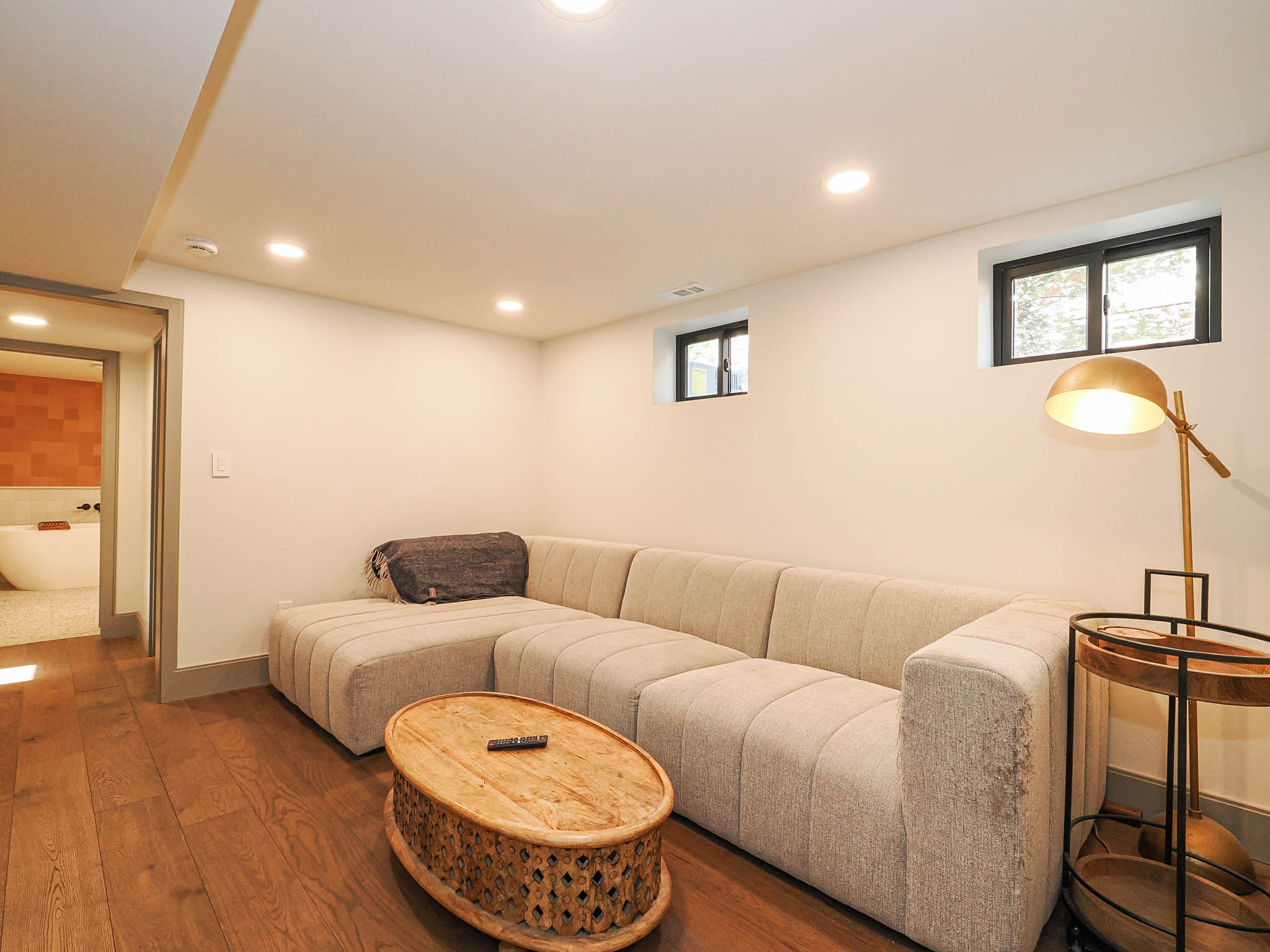 Finished living space featuring wood-finish flooring, recessed lighting, and two high-set windows