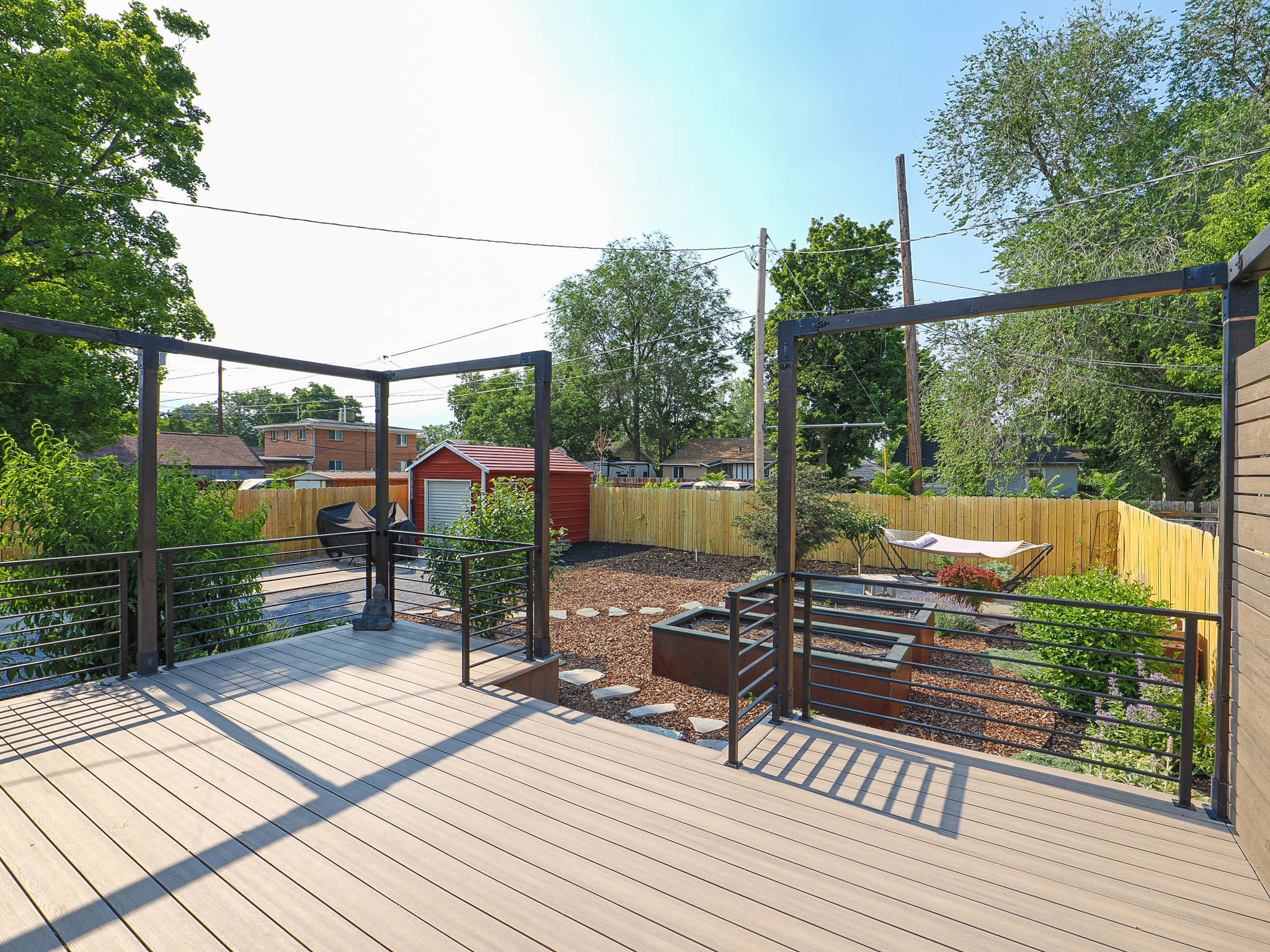 Spacious composite deck with dark metal railings and pergola structure