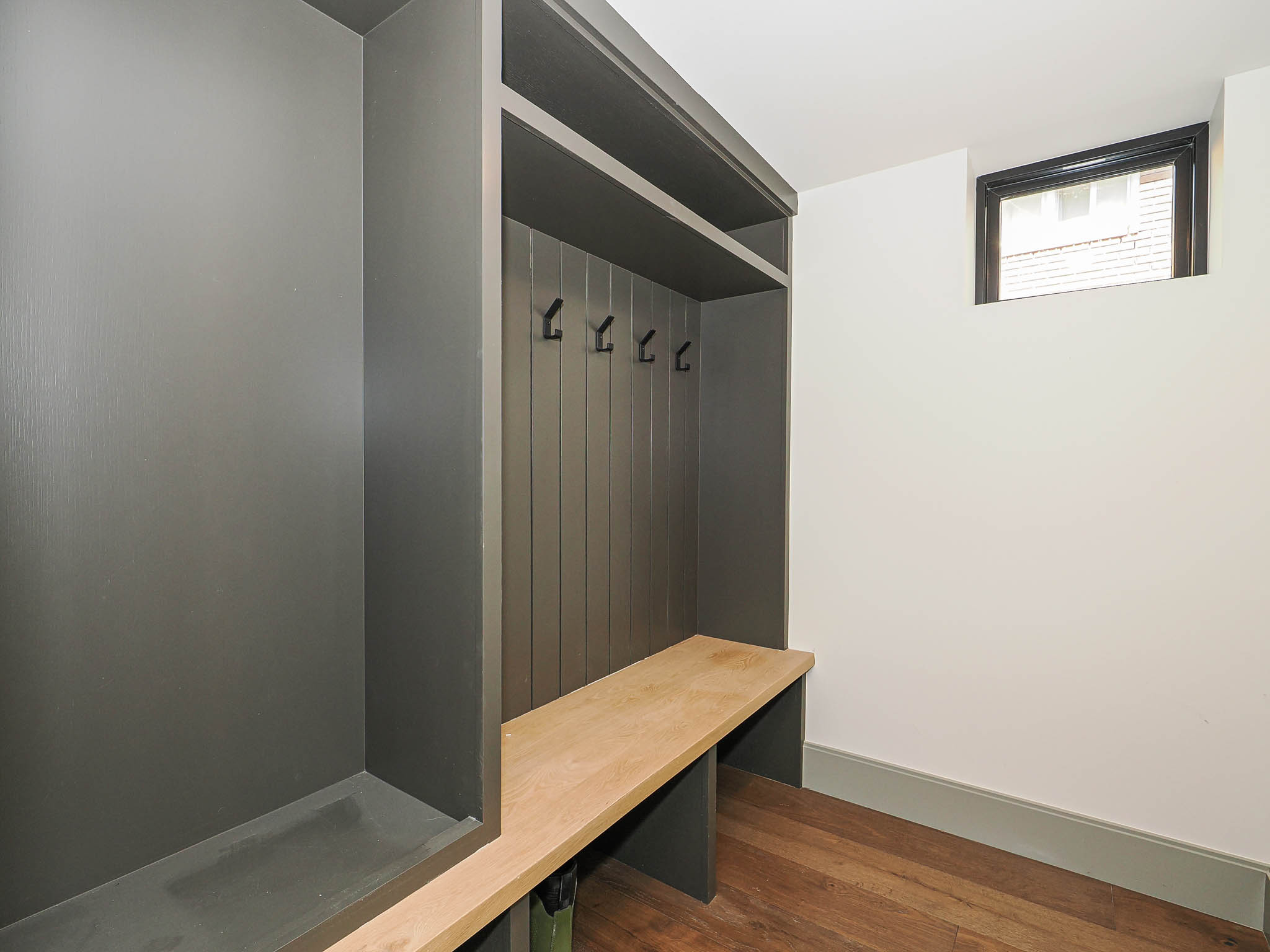 Built-in hall tree with a natural wood-finish bench and shelving