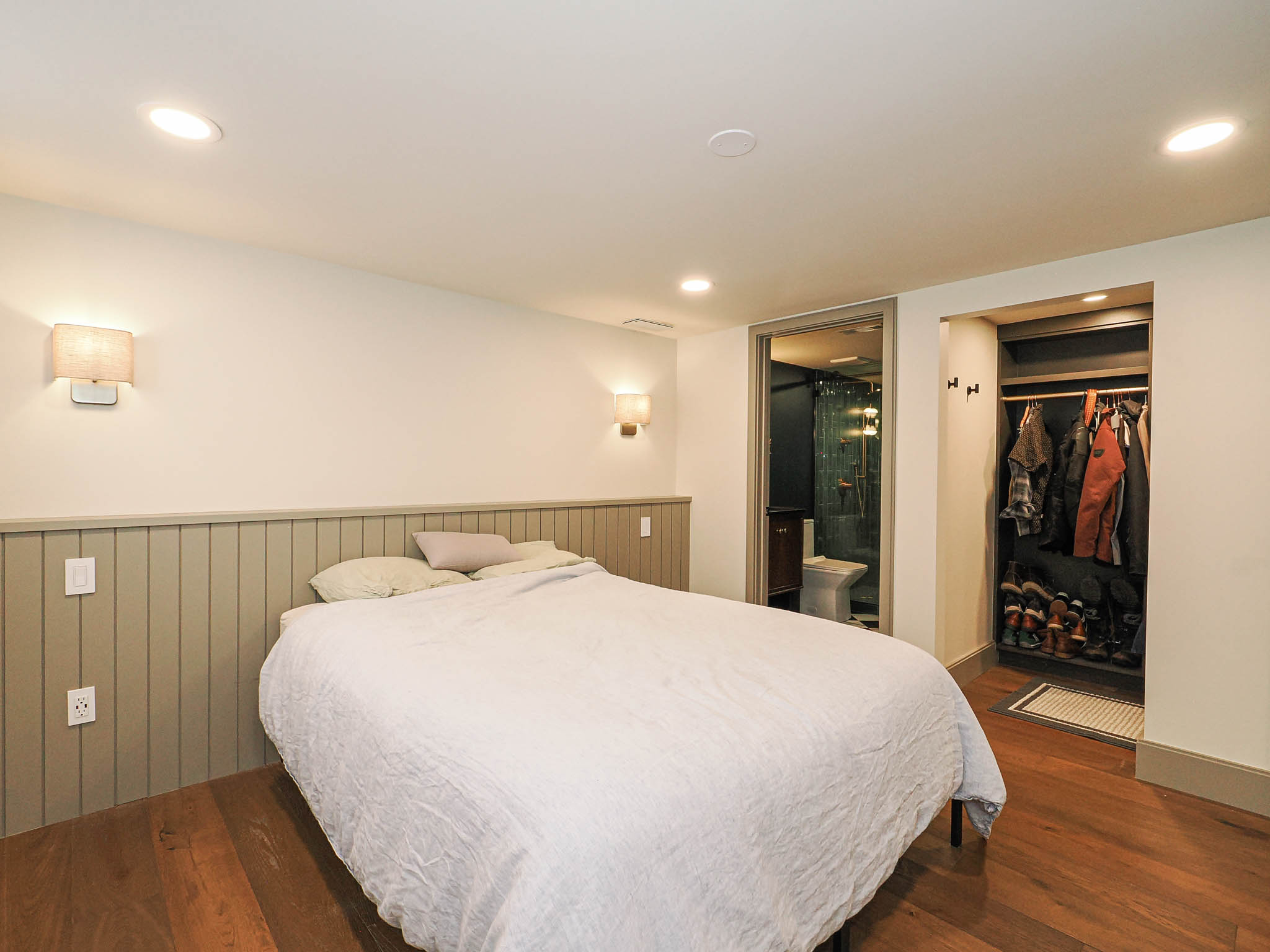 Hardwood flooring throughout featuring recessed lighting and wall sconces