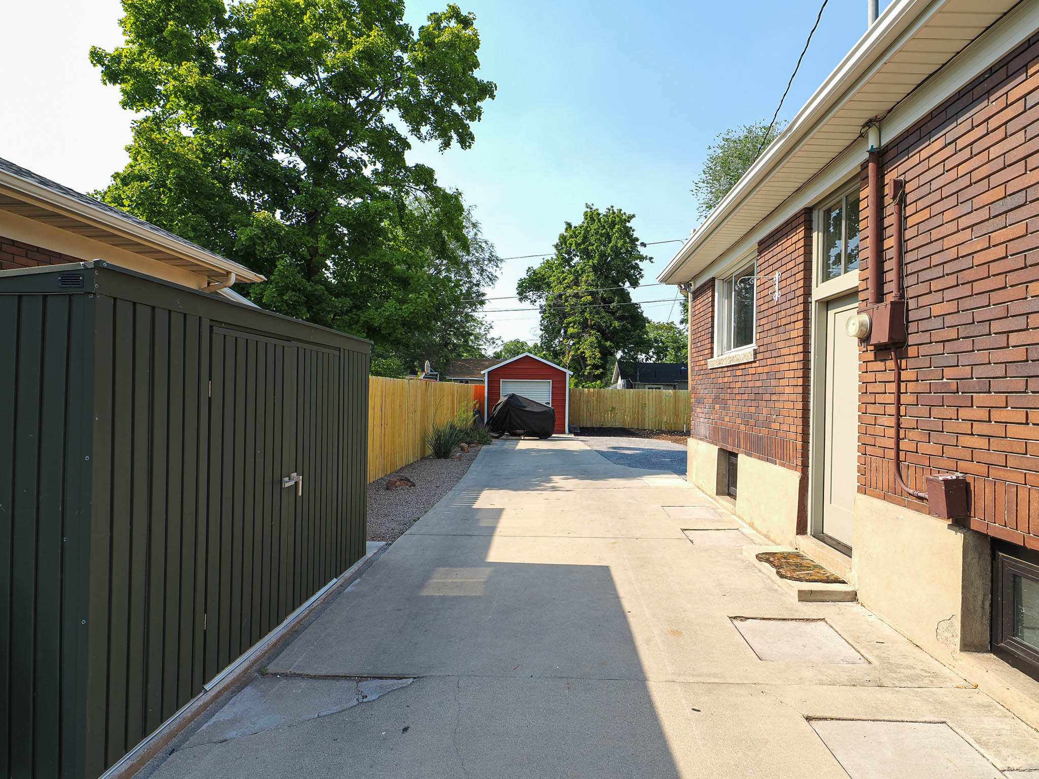 Concrete driveway extending to a detached red garage