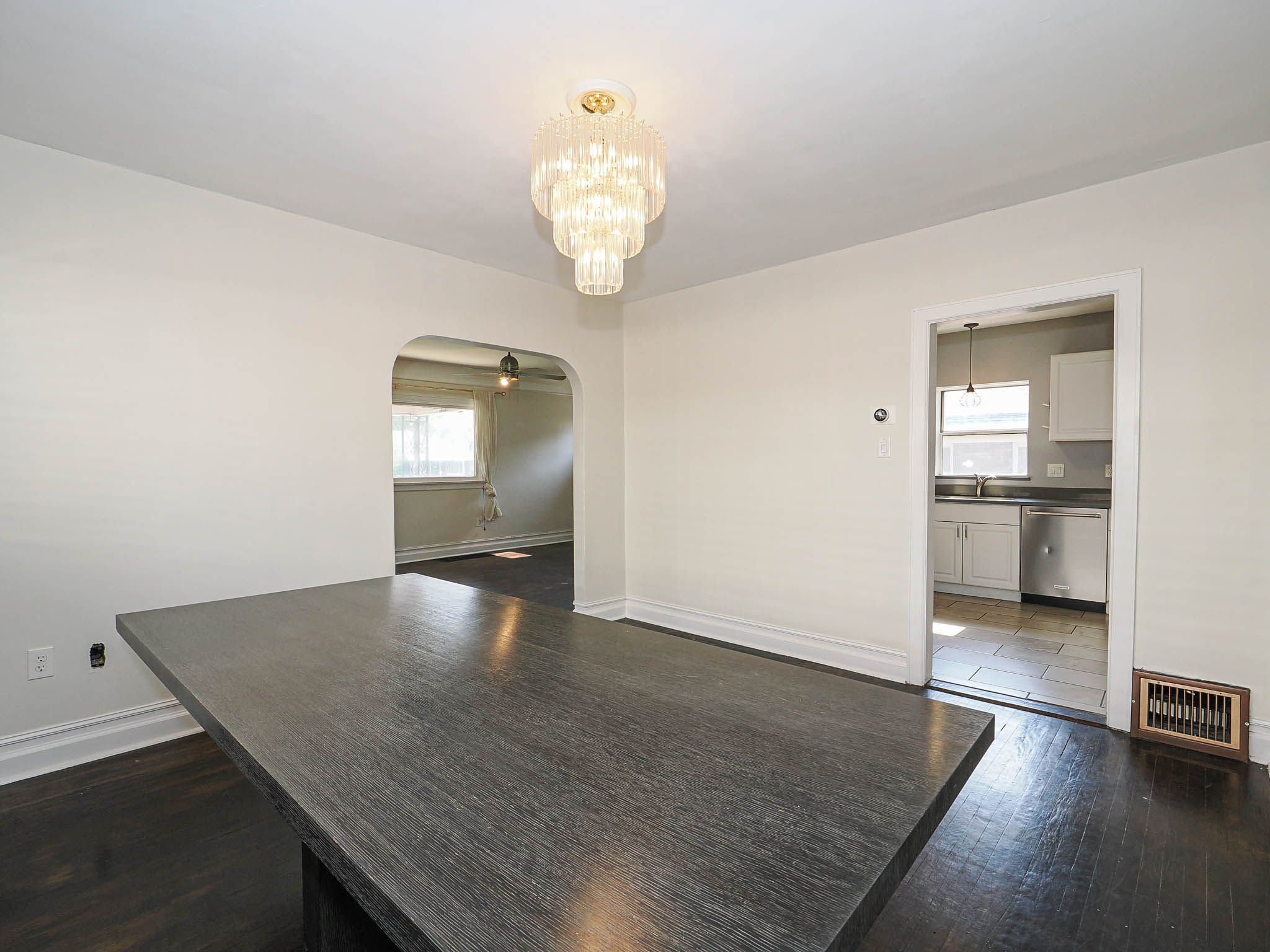 Dining area featuring a contemporary chandelier and dark wood-finish flooring