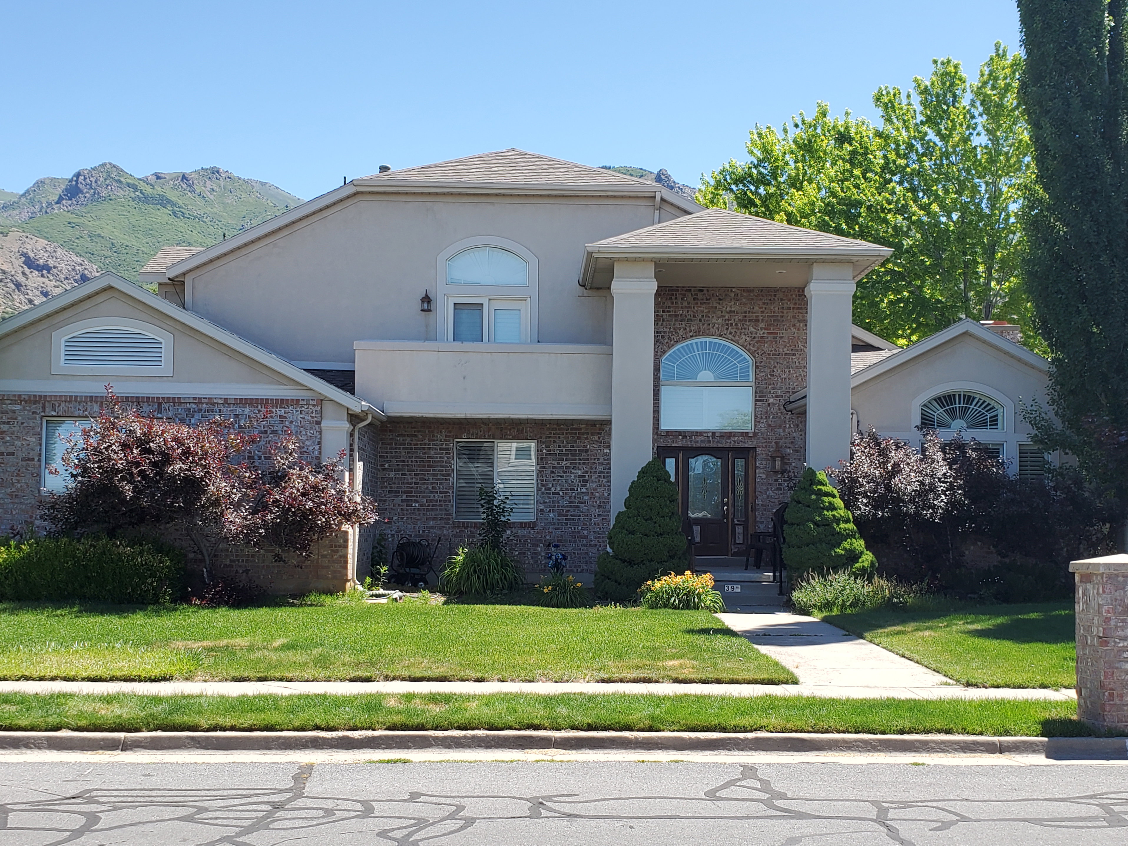 Stately residence featuring a brick and stucco exterior, arched windows, and a prominent columned entrance