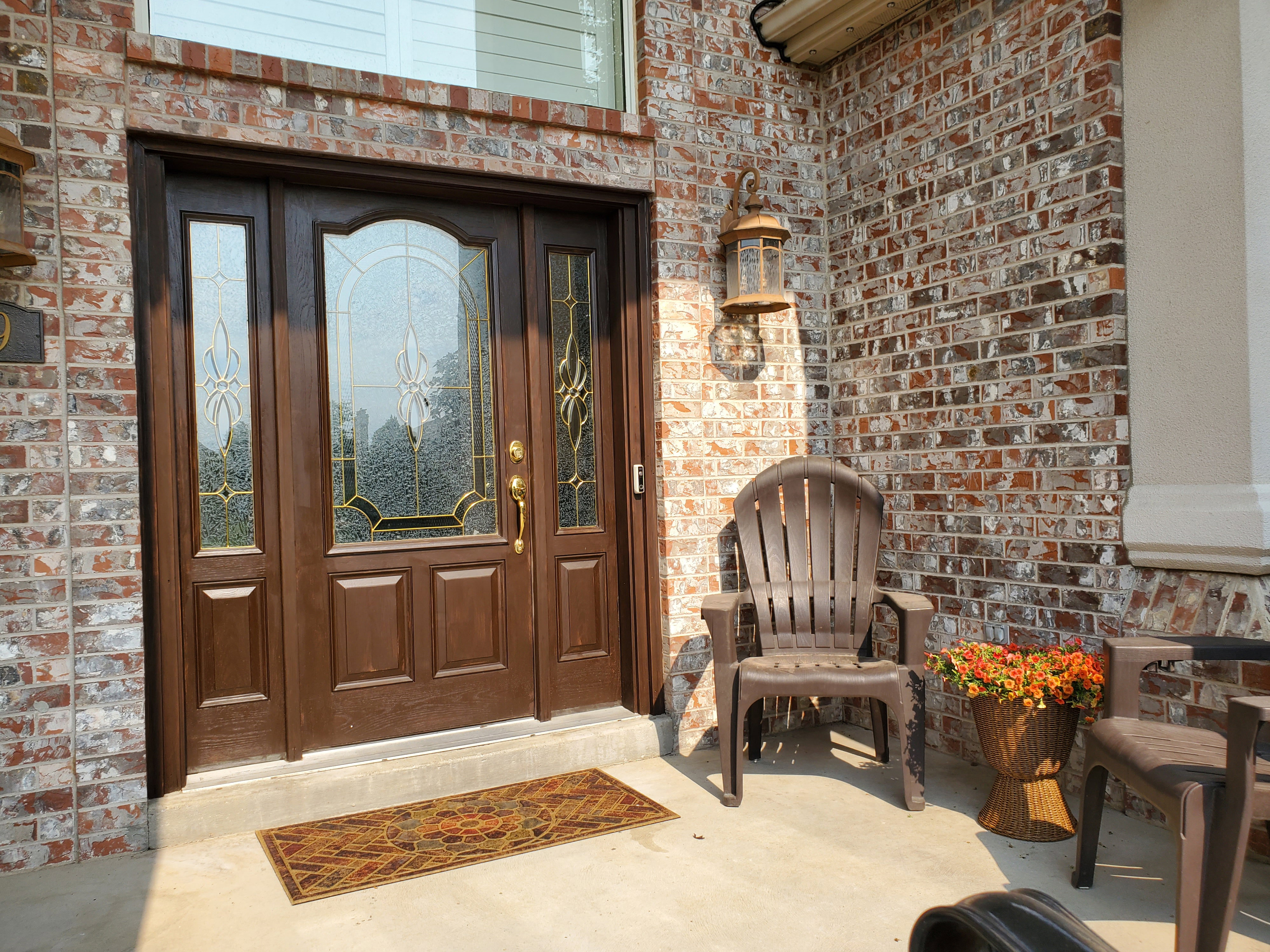 Front entry featuring a richly stained door with decorative glass side panels and transom