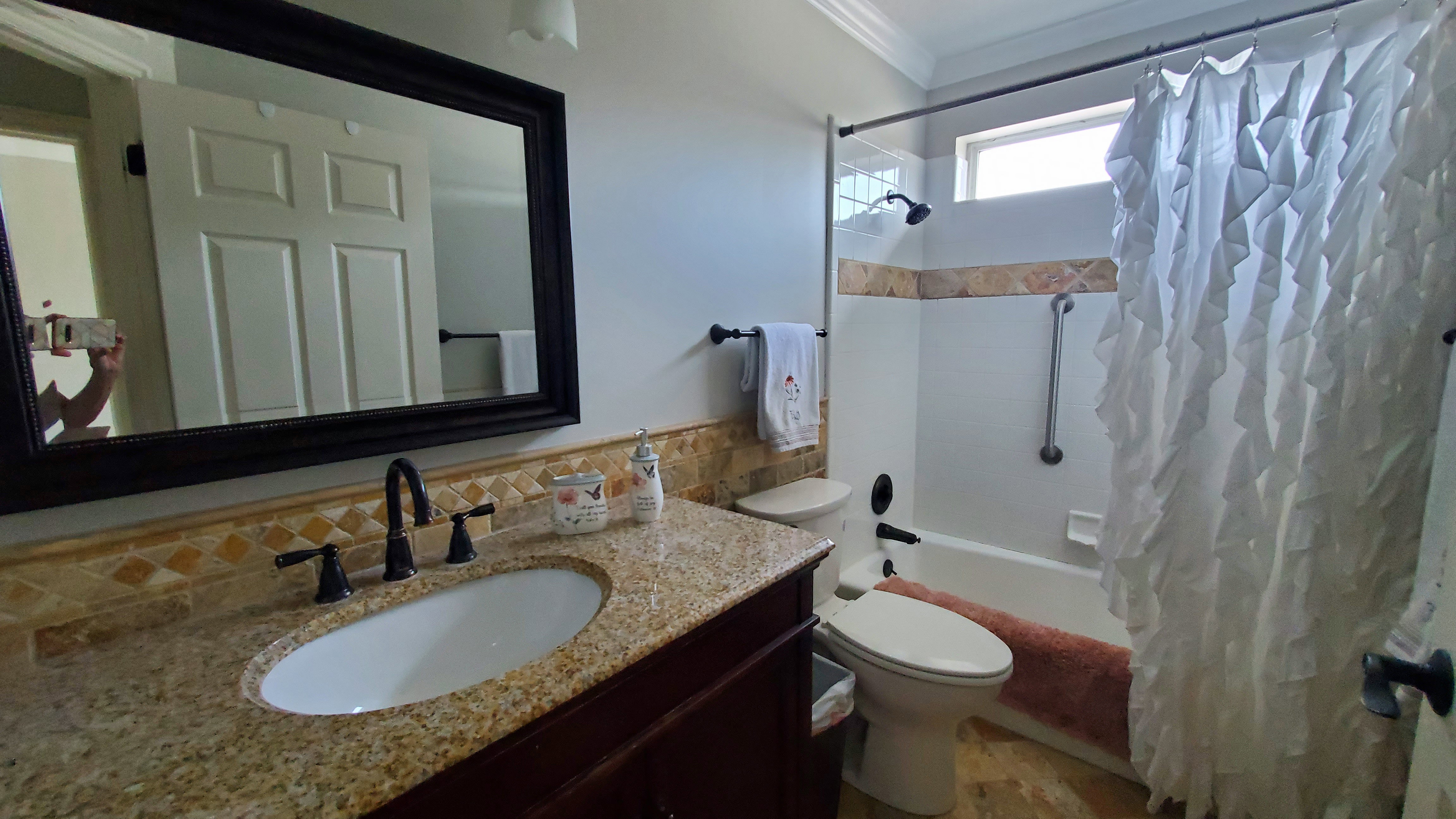 Bathroom featuring a dark wood-finish vanity with a granite countertop and an undermount sink