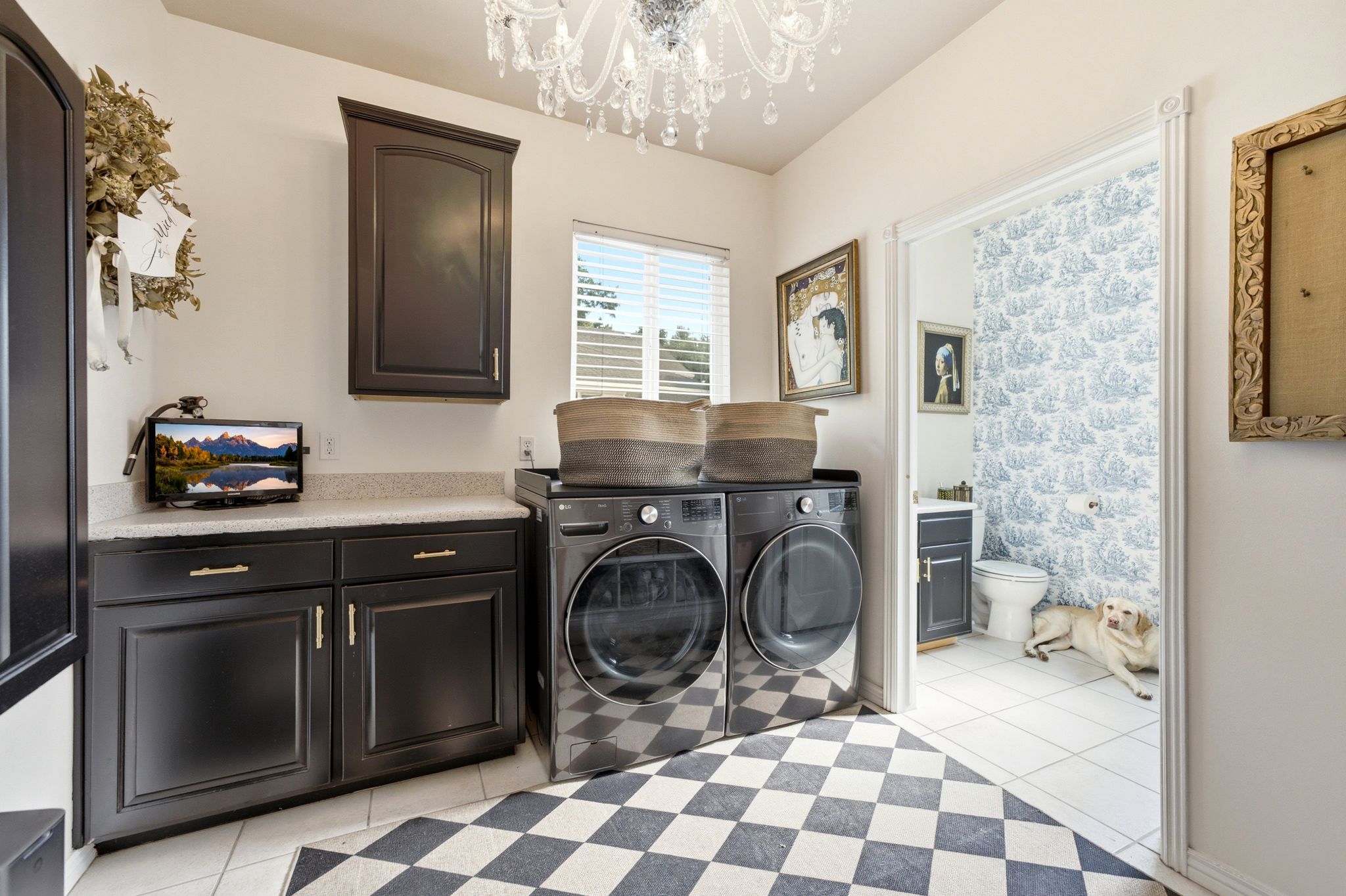 Dedicated laundry room featuring dark cabinetry, a light-colored countertop, and a window for natural light