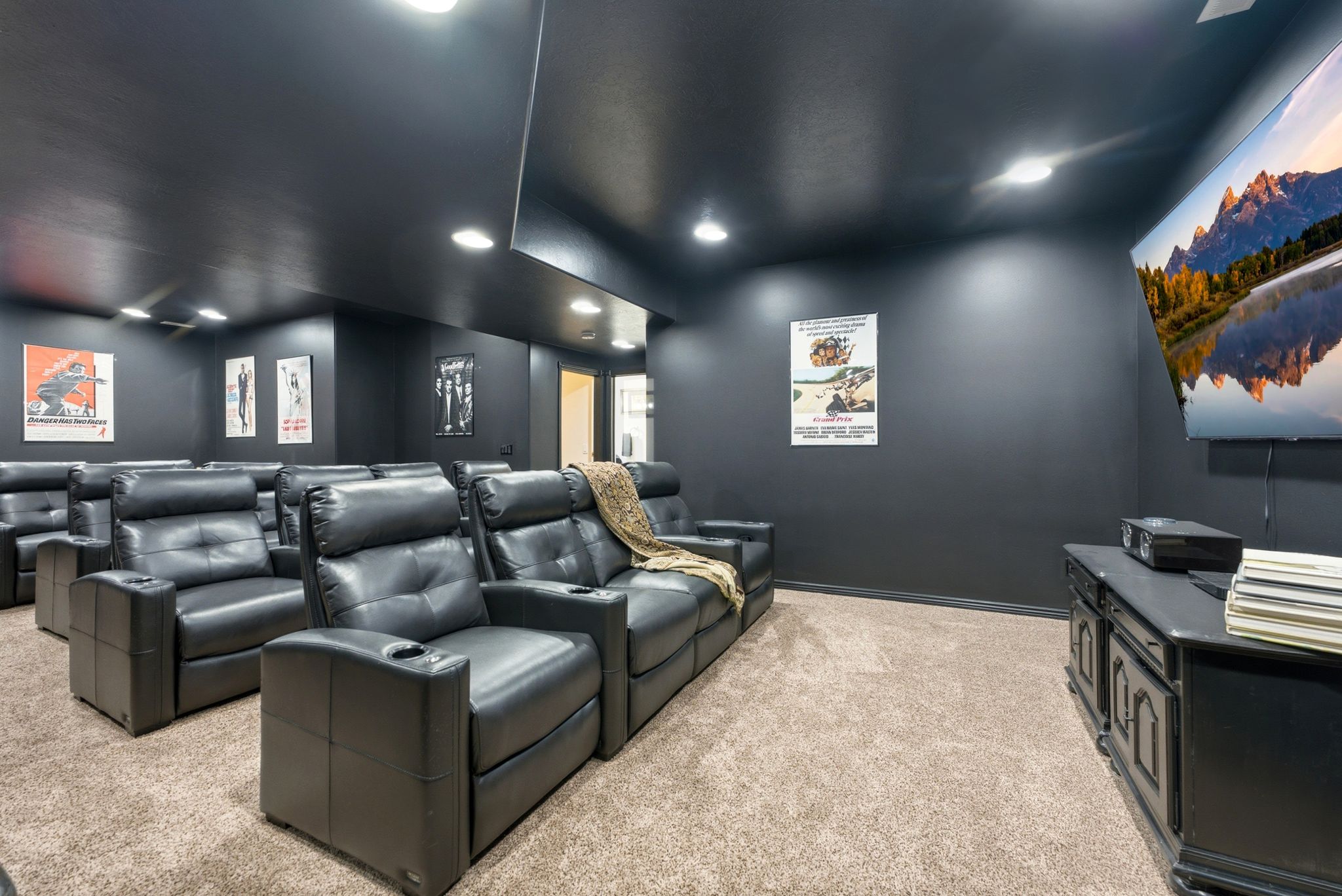 Dedicated entertainment room featuring dark-painted walls and ceiling, recessed lighting, and carpet flooring