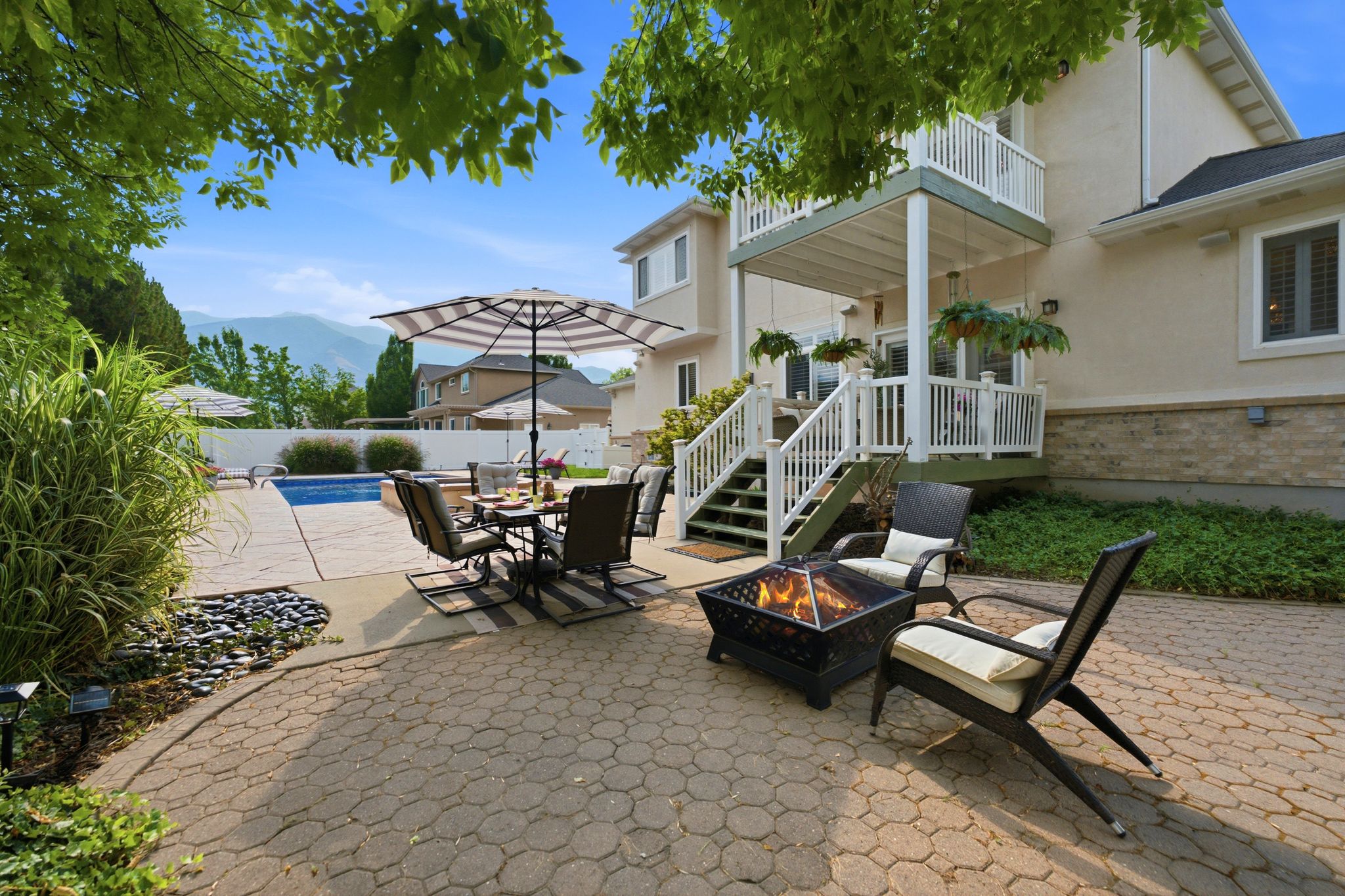 Expansive backyard featuring a paver patio, a fire pit, and a swimming pool