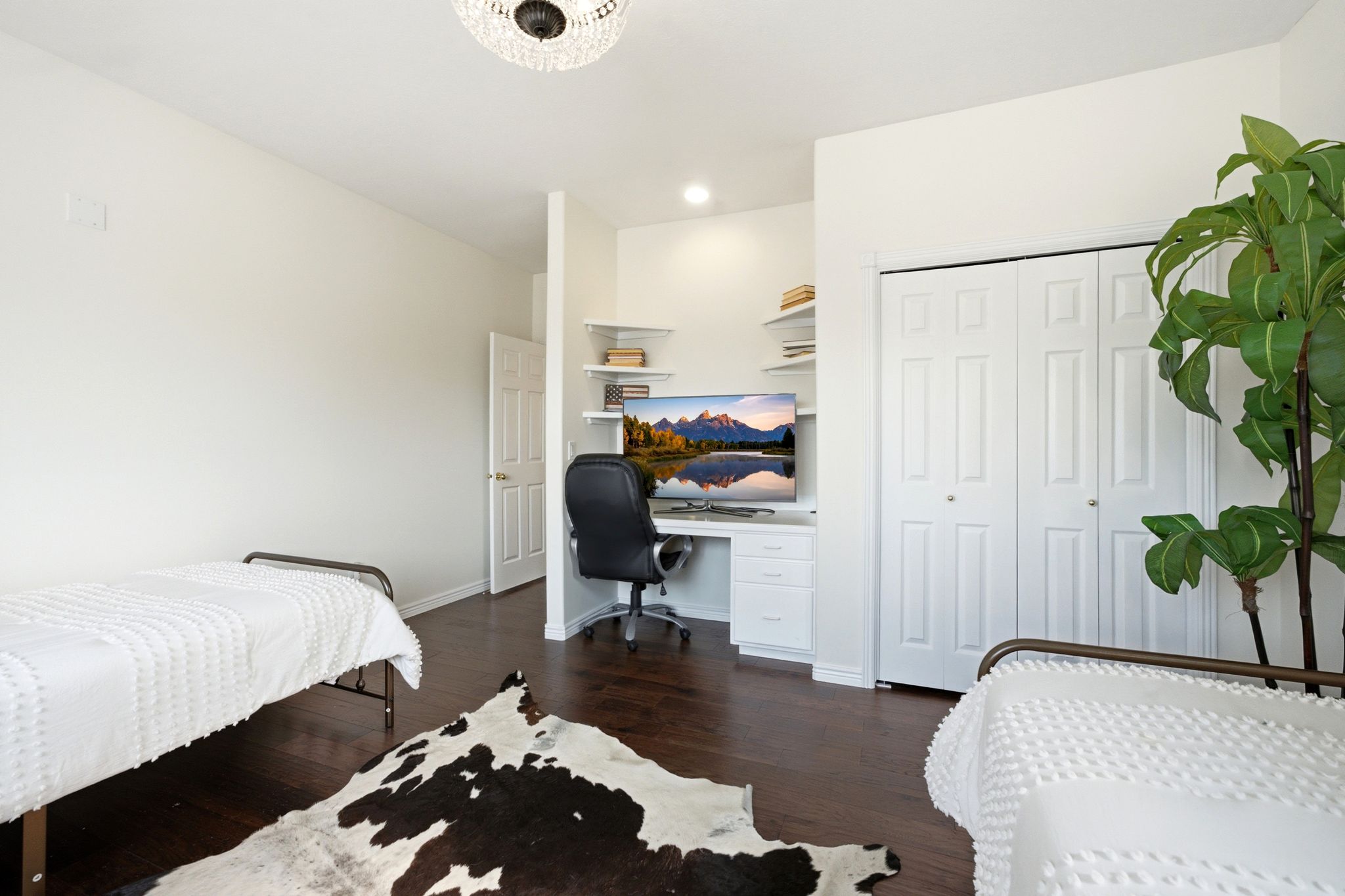Built-in desk area with shelving, dark wood-finish flooring, white bifold closet doors, recessed lighting, and a decorative ceiling fixture