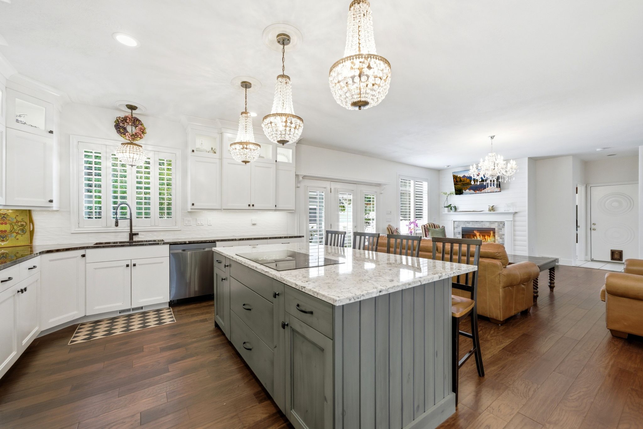 Kitchen featuring an expansive center island with seating, pendant lighting, white cabinetry, and stainless steel appliances