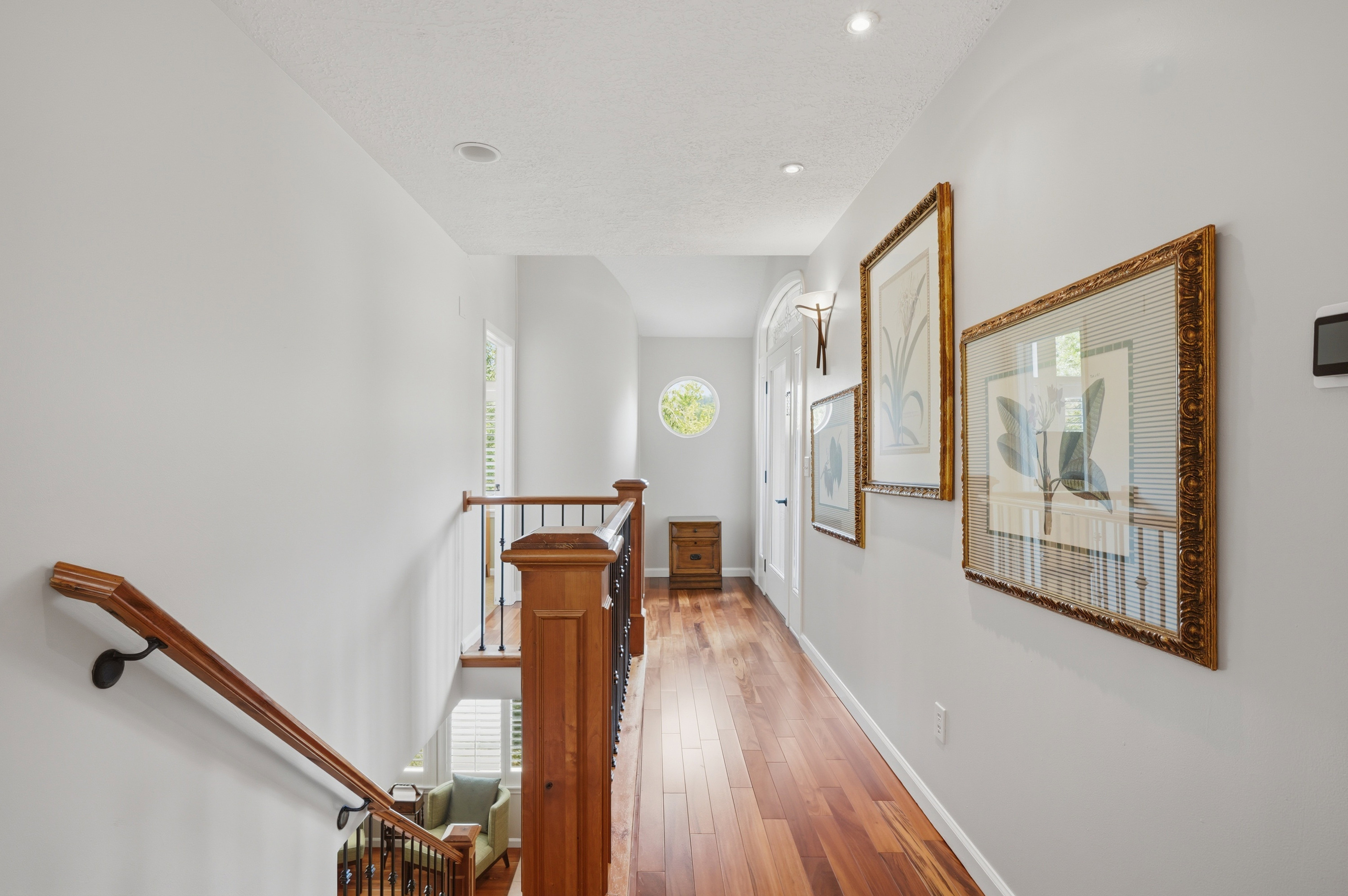 Hallway featuring wood flooring, recessed lighting, and cute round window