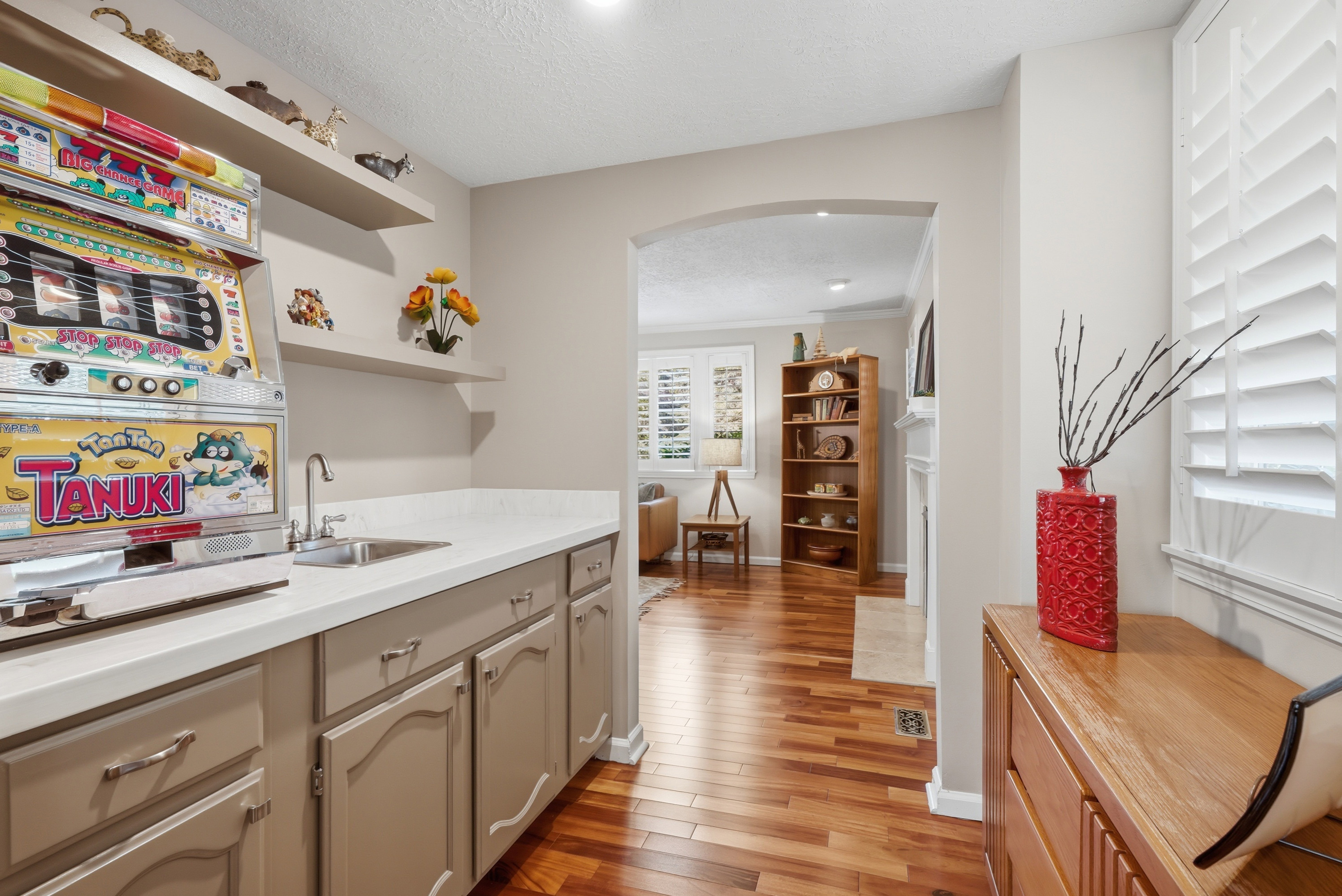 Wet bar featuring a stainless steel sink, and light countertops
