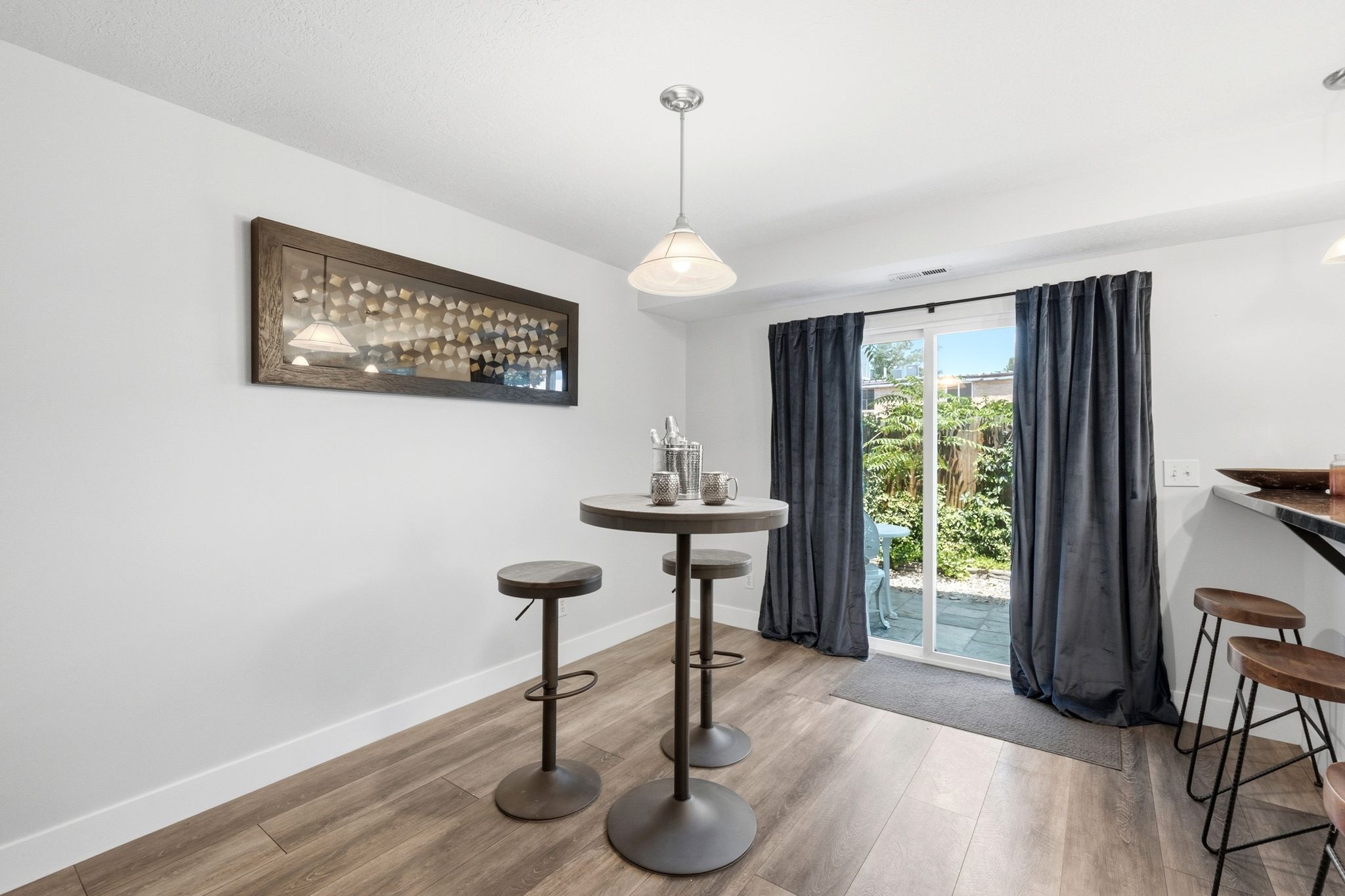 Interior space featuring wood-finish flooring, white walls, and a recessed ceiling with a pendant light fixture