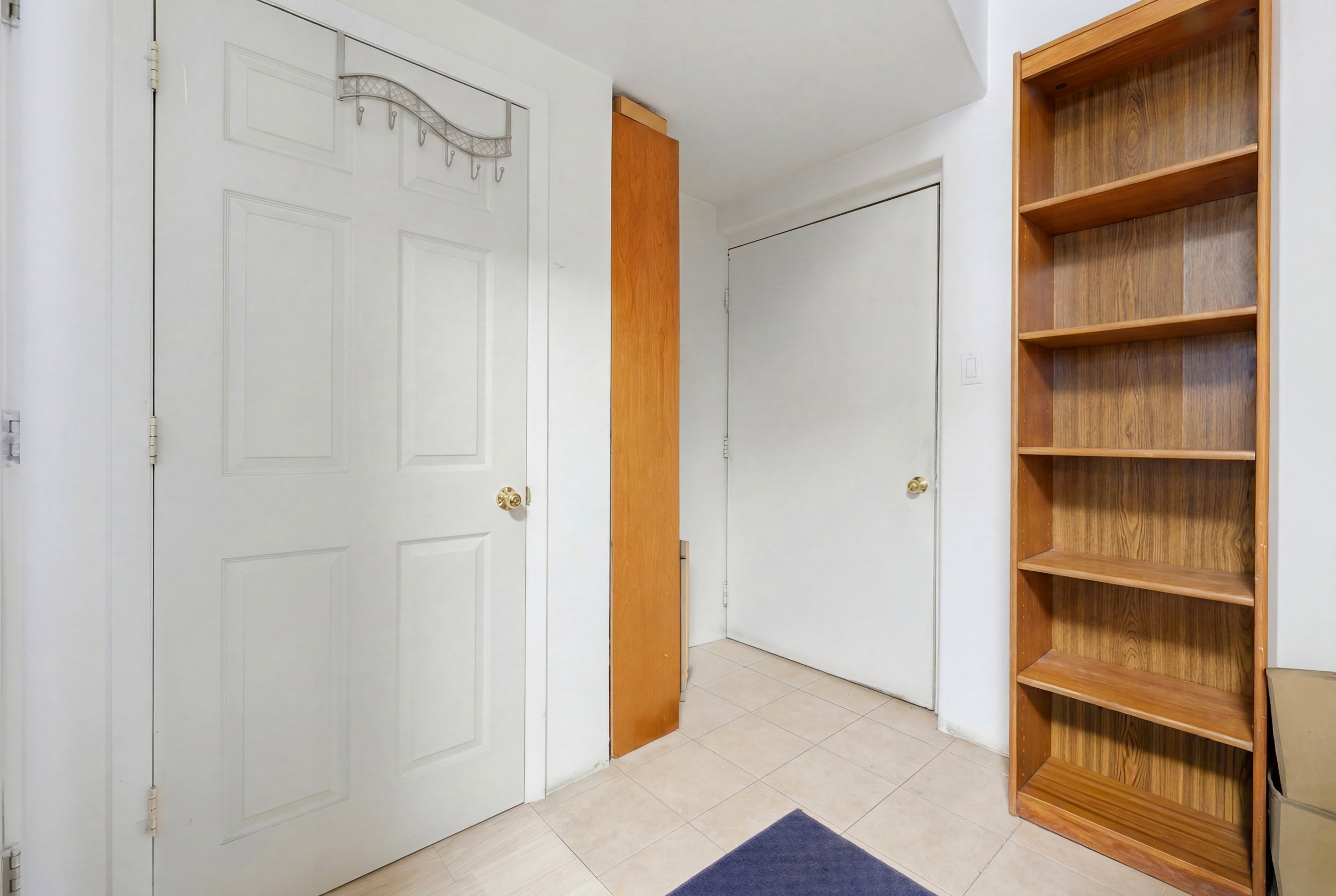 Tiled flooring complementing white panel doors and a wood-finish bookcase