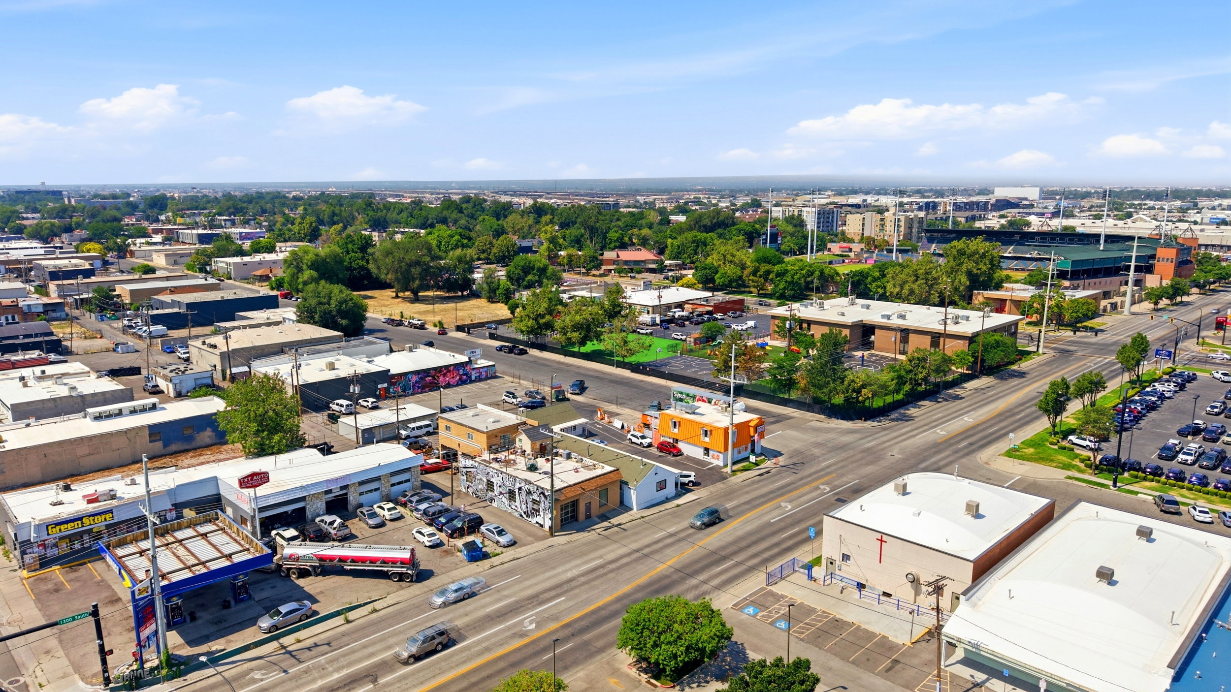 Urban commercial area featuring multiple buildings, paved roads, and various businesses