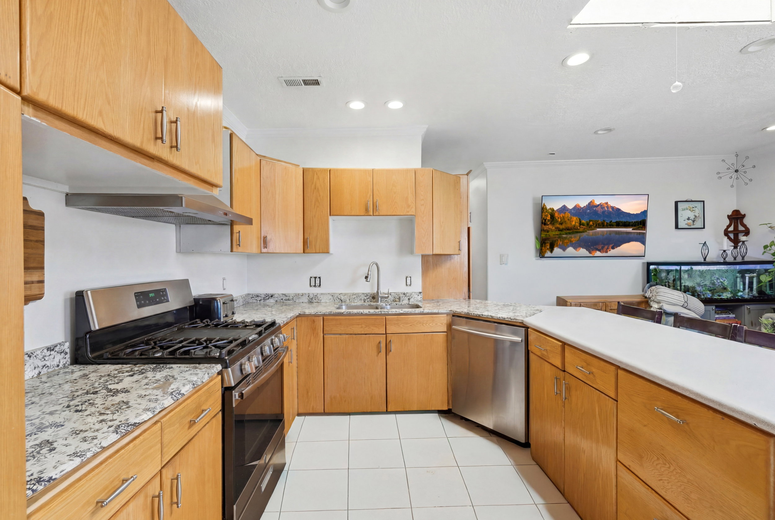 Kitchen featuring natural wood cabinetry and light-toned granite countertops